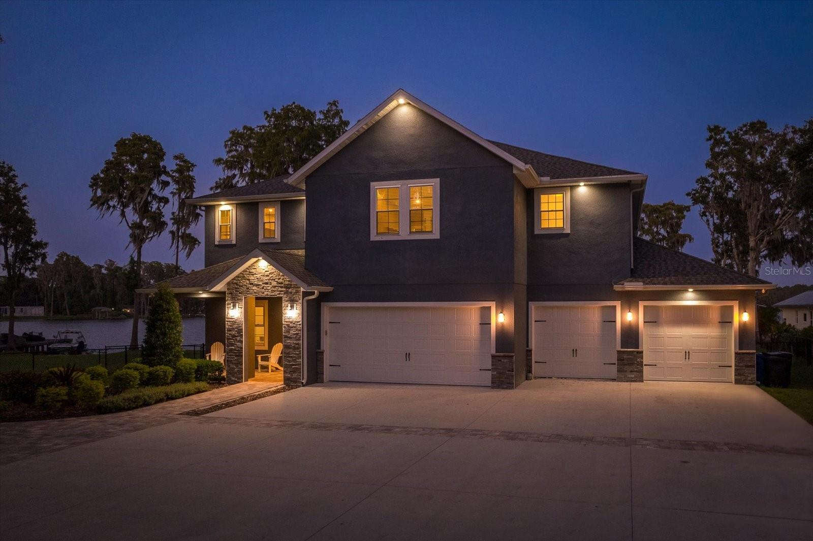 WELCOME HOME to the unparalleled luxury and peacefulness at this Lake Osceola haven in Odessa. Custom Built in 2019 by Sunshine Builders (established in 1960), using top-notch construction methods and modern finishes, this bespoke lakefront sanctuary sprawls across 5,125 sq ft of heated and cooled lavish interiors, set on a remarkable 100’ of lakefront land by the private, 59-acre Lake Osceola. The residence houses four bedrooms and four bathrooms, each epitomizing contemporary luxury, with virtually the entire living space offering sweeping vistas of the lakefront. Culinary aficionados will appreciate the kitchen, outfitted with solid wood cabinetry, a grand central island, quartz countertops, and elite stainless steel appliances.
The primary suite is a study in sophistication and relaxation, offering a capacious spa-like bathroom with dual vanities and a whirlpool tub, not to mention a private office with lake views and a secluded outdoor sitting area that encourages peaceful reflection amidst beautiful scenery. Your wellness journey is catered for with a dedicated home gym on the main floor, while the expansive family rooms on both levels foster joyous family congregations.
The entrance, adorned with a refined sitting room, guides you to a vast space harboring the dining, kitchen, and living areas. The outdoor environs echo paradise, featuring an oversized pool and a spa with LED lighting, impeccably maintained landscapes, and direct passage to a dock and boathouse, ushering you into a world of aquatic sports and splendid fishing experiences. Additionally, an ample storage shed takes care of your lake paraphernalia and gardening tools. The generous four-car garage not only shelters your vehicles but avails a workshop space for enthusiasts.
Positioned close to top-ranking schools, delightful parks, and premium golf courses, this dwelling transcends mere habitation to offer a gateway to a heavenly Florida lifestyle. Schedule your viewing today to personally witness this embodiment of excellence and luxury. Zillow 3D Tour: https://www.zillow.com/homedetails/19717-Gunn-Hwy-Odessa-FL-33556/44846096_zpid/?mmlb=t,0