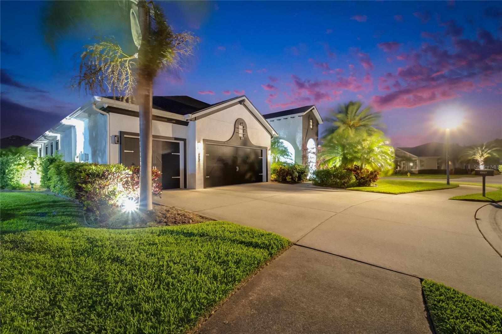 Exquisite Waterset Rare Gem on an Oversized Corner Lot!! Welcome to an exceptional 4-bedroom, 3-bathroom home in the highly sought-after Waterset Community. Designed with contemporary elegance, this home blends modern luxury with inviting charm. Situated on an oversized 0.34-acre fully fenced corner lot, the property is a masterpiece of style and convenience. From the moment you arrive, the spectacular exterior landscape lighting creates a welcoming ambiance, illuminating the trees, walking paths, and lush greenery. Maintaining that beautiful lawn is effortless with an eight-zone reclaimed water irrigation system, ensuring vibrant greenery year-round. Plus, this home features a brand-new roof completed in December 2022, built with premier materials for durability and longevity. Inside, the open floor plan is designed for both comfort and entertaining. The chef’s kitchen is an absolute dream, featuring three ovens—a Kucht Professional KFX Series gas oven, along with a GE Café double oven that can be controlled remotely through WiFi. The Fisher & Paykel Double Drawer Dishwasher and Zline microwave add both convenience and style. The kitchen is stunning, with quartz countertops, a marble backsplash, a farmhouse sink, and even a pot filler above the stove for added ease while cooking. Entertainment is effortless with a Sony surround sound system that fills the home and extends out onto the lanai. Watch your favorite shows on the Samsung 75” Frame TV, or take the fun outside to enjoy the lanai’s outdoor TV. The lanai is designed for ultimate relaxation, with shades that can be adjusted to give you complete control over sunlight and privacy. Throughout the home, every detail has been thoughtfully upgraded to reflect the beauty of contemporary farmhouse design. The wet bar and electric heat-lighted fireplace create a cozy yet modern atmosphere. Upgraded farmhouse lighting adds warmth and character, while custom shelving in both primary bedroom closets, as well as in the pantry and laundry room, offers exceptional storage solutions. There’s no carpet in this home, just beautiful, high-quality flooring throughout. For added comfort, the home features a premium water softener system and a reverse osmosis system, ensuring clean, fresh water at all times. This home has a tankless gas water heater and the home is smart-controlled with Google WiFi, including the gas-powered AC units, which can be adjusted with a simple tap on your phone. Hurricane shutters are included for peace of mind, and there’s even a 220-amp connection on the lanai, ready for a hot tub. Beyond this incredible home, the Waterset community itself offers an unbeatable lifestyle. Residents enjoy resort-style pools, a variety of parks, more than 12 miles of scenic trails, two fully equipped fitness centers, pickleball, basketball, and volleyball courts for endless recreation. There’s also a dog park where furry friends can run and play. Plus, shopping, dining, and everyday conveniences are just minutes away. This home isn’t just a place to live—it’s a place to truly love. Don’t just dream about it—experience it for yourself. Schedule your private showing today and step into the extraordinary!