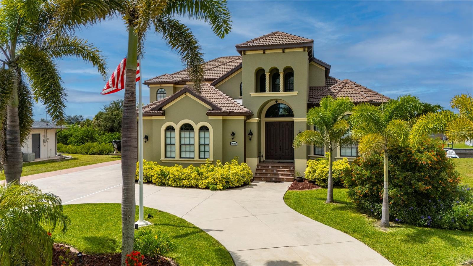 Some homes quietly check the boxes. Others stir something deeper the moment you arrive. From the soft rustle of palm fronds in the breeze to the glint of sun dancing across the canal, this custom 4 bedroom, 4.5 bathroom, 3 car garage waterfront estate in the Port Charlotte Beach area offers more than luxury- it offers a coastal sanctuary. Sailboat-accessible with no fixed bridges, 80 feet of waterfront, and a private 60ft dock with a 24,000lb lift, this is a property designed for those who feel most at home on the water-yet crave elegant living on land. Every inch of this residence reflects thoughtful design and enduring craftsmanship. The entry opens into soaring, light-filled spaces framed by arched passageways, tray ceilings, and stately columns. An elegant double-sided gas fireplace warms both the formal dining room and private office, while plantation shutters, crown molding, and curated finishes add warmth and sophistication. The heart of the home is its gourmet kitchen, seamlessly blending form and function. Solid wood cabinetry, granite countertops, and stainless steel appliances are complemented by an induction cooktop, built-in oven, microwave, warming drawer, and a wine bar with a wine fridge. Whether you're hosting holiday dinners or quiet evenings for two, the layout invites connection and conversation. The first-floor primary suite feels like a private wing, with a spacious walk-in closet and a spa-like bath that features a jetted soaking tub, Roman-style shower with multiple heads, and dual vanities. Upstairs, three oversized bedrooms and two full baths offer privacy and flexibility for family or guests. One bedroom enjoys an en suite, while the other two share a Jack-and-Jill layout. A secluded loft with a balcony offers a peaceful perch overlooking the pool-a perfect morning retreat or creative hideaway. Step outside and the story deepens. A screened porch with double doors leads to the lanai with a heated saltwater pool framed by paver decking, lush tropical landscaping, and a custom tiki hut with a fully equipped outdoor kitchen. It’s a space built for memory-making-from sunlit pool days to starlit dinners by the water. And beyond the beauty? The peace of mind that comes with knowing this home has been impeccably maintained: a new tile roof (2022), impact-resistant windows, new A/C systems with zoned climate control, new pool heater, pump, and salt system, new carpeting, and fresh interior and exterior paint. A circular paver driveway and side-loading 3-car garage offer convenience and curb appeal in equal measure. With no HOA, no deed restrictions, and no flooding or hurricane damage from recent storms, this home offers rare freedom along with its luxury. And the location places you just minutes from Port Charlotte Beach Park, the Sunseeker Resort, golf courses, restaurants, Punta Gorda airport, I-75, and the charm of historic downtown Punta Gorda. Whether it’s a full-time residence or seasonal escape, this is more than just a place to live—it’s a setting for the life you’ve worked hard to create.
