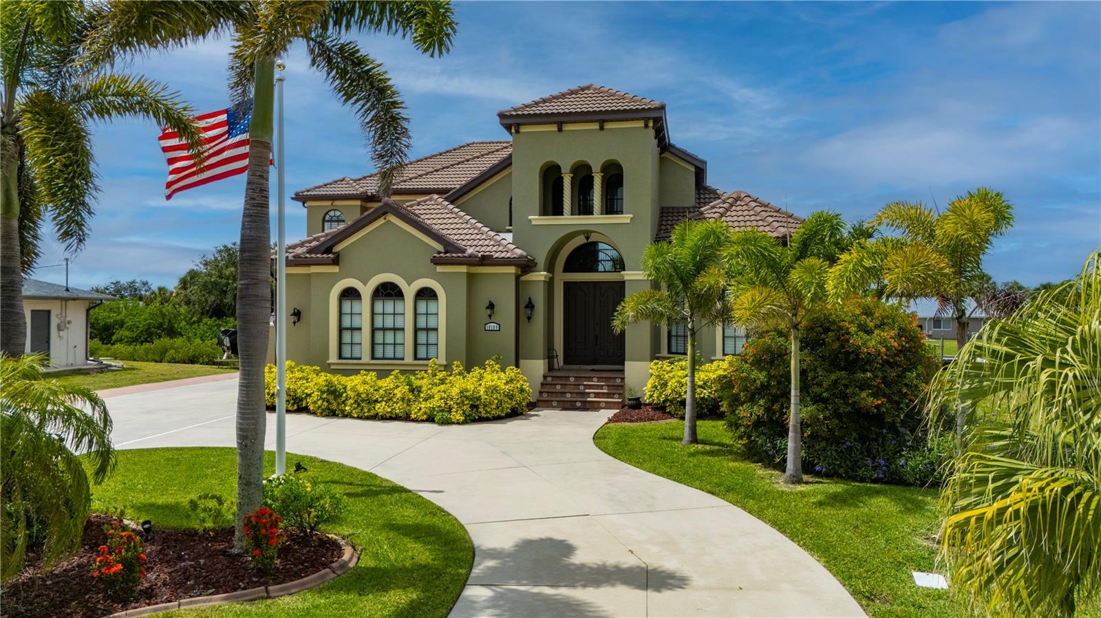 Some homes quietly check the boxes. Others stir something deeper the moment you arrive. From the soft rustle of palm fronds in the breeze to the glint of sun dancing across the canal, this custom 4 bedroom, 4.5 bathroom, 3 car garage waterfront estate in the Port Charlotte Beach area offers more than luxury- it offers a coastal sanctuary. Sailboat-accessible with no fixed bridges, 80 feet of waterfront, and a private 60ft dock with a 24,000lb lift, this is a property designed for those who feel most at home on the water-yet crave elegant living on land. Every inch of this residence reflects thoughtful design and enduring craftsmanship. The entry opens into soaring, light-filled spaces framed by arched passageways, tray ceilings, and stately columns. An elegant double-sided gas fireplace warms both the formal dining room and private office, while plantation shutters, crown molding, and curated finishes add warmth and sophistication. The heart of the home is its gourmet kitchen, seamlessly blending form and function. Solid wood cabinetry, granite countertops, and stainless steel appliances are complemented by an induction cooktop, built-in oven, microwave, warming drawer, and a wine bar with a wine fridge. Whether you're hosting holiday dinners or quiet evenings for two, the layout invites connection and conversation. The first-floor primary suite feels like a private wing, with a spacious walk-in closet and a spa-like bath that features a jetted soaking tub, Roman-style shower with multiple heads, and dual vanities. Upstairs, three oversized bedrooms and two full baths offer privacy and flexibility for family or guests. One bedroom enjoys an en suite, while the other two share a Jack-and-Jill layout. A secluded loft with a balcony offers a peaceful perch overlooking the pool-a perfect morning retreat or creative hideaway. Step outside and the story deepens. A screened porch with double doors leads to the lanai with a heated saltwater pool framed by paver decking, lush tropical landscaping, and a custom tiki hut with a fully equipped outdoor kitchen. It’s a space built for memory-making-from sunlit pool days to starlit dinners by the water. And beyond the beauty? The peace of mind that comes with knowing this home has been impeccably maintained: a new tile roof (2022), impact-resistant windows, new A/C systems with zoned climate control, new pool heater, pump, and salt system, new carpeting, and fresh interior and exterior paint. A circular paver driveway and side-loading 3-car garage offer convenience and curb appeal in equal measure. With no HOA, no deed restrictions, and no flooding or hurricane damage from recent storms, this home offers rare freedom along with its luxury. And the location places you just minutes from Port Charlotte Beach Park, the Sunseeker Resort, golf courses, restaurants, Punta Gorda airport, I-75, and the charm of historic downtown Punta Gorda. Whether it’s a full-time residence or seasonal escape, this is more than just a place to live—it’s a setting for the life you’ve worked hard to create.