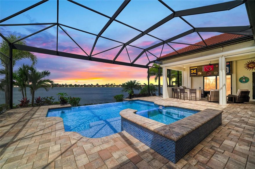 Designed with coastal elegance in mind and offering a prime western exposure for unforgettable Florida sunsets, this magnificent 3,724sf Villa Serena is situated on an expansive 80-foot-wide lakefront lot with breathtaking views of picturesque Lake Awesome. This remarkable property seamlessly blends luxury with tranquil waterfront living, featuring three generously sized bedrooms, a dedicated office, an additional bonus room, a spacious outdoor area, a spectacular infinity-edge pool and spa, an outdoor kitchen with large bar, and a built-in, motorized outdoor TV for enjoying your favorite sports events. From the moment you enter the impressive double entry doors, you'll be captivated by the stunning panoramic views of sparkling water. This home boasts dramatic volume and coffered ceilings, accentuated by driftwood-inspired tongue-and-groove details, a spectacular built-in entertainment center with electric fireplace, abundant cabinetry, open shelving, elegant crown molding, stylish designer lighting, 12x24 porcelain tile flooring in the common areas, and plush, brand-new carpets in the bedrooms. The gourmet kitchen is equipped with top-of-the-line KitchenAid built-in appliances, including a spacious 42-inch refrigerator, a gas cooktop, a built-in oven, a microwave, and a sleek stainless steel hood vent. Soft white wood cabinets, crowned with exquisite molding, stylish under-cabinet lighting, and an eye-catching backsplash complement gorgeous quartz countertops and a large kitchen island, which includes a discreet walk-in pantry for all your storage needs. The expansive lanai with outdoor kitchen and a spacious bar area is perfect for delightful al fresco dining and entertaining. The primary suite features an en-suite bathroom with dual vanities, a designated makeup counter, an inviting garden tub, and a spacious shower, all finished with luxurious touches. With two custom closets and a generously sized bedroom adorned with a large panoramic window overlooking Lake Awesome, this suite embodies tranquility. This residence offers both comfort and safety, boasting two HVAC units, hurricane-impact windows and doors, a tankless gas water heater, and a 250-gallon in-ground propane tank. Plus, with Storm Smart hurricane screens installed, you can enjoy peace of mind and added protection. The three-car, side-entry garage is air-conditioned and features an epoxy slip-resistant floor, functional hanging storage racks, and an electric lift for convenient attic access. At Toscana Isles, you'll experience a lifestyle akin to a permanent vacation in a gated, resort-style community designed for those who value an active and fulfilling life. Enjoy over 200 acres of interconnected lakes, offering fantastic opportunities for kayaking, canoeing, and fishing right in your backyard. The impressive 8,000-square-foot clubhouse includes a fully equipped fitness center, ballroom, and billiard room, creating the ideal space for building new friendships and enjoying community amenities. You're also only 10 minutes from the stunning Suncoast beaches and the Legacy Bike Trail, and a short drive to the vibrant downtown areas of Venice and Sarasota, making it perfect for leisure and cultural exploration. For added convenience, Sarasota Memorial Hospital's Venice campus is just 5 minutes away. Most of the furnishings are available for purchase via a separate bill of sale. Call today to schedule your private showing!