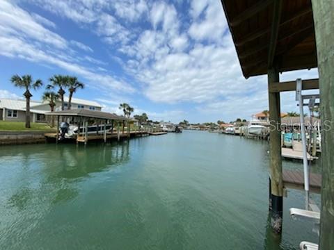 Beachside Direct Intracoastal access. 4 Bdr, 4 1/2 bath, 2 car sideload garage. Yr built 2019 pool home with docks, 10,000 lb lift in covered boathouse in one of New Smyrna Beach's most coveted communities, Venezia. The exterior of this home boasts coastal allure and integrity with hariboard siding over concrete block with standing seam metal roof. A Hardy Generac whole house generator is just off to the side of the garage. Aluminum acqua shutters adorn windows. On the waterside is a 58' x 15' covered back patio with summer kitchen, accessed by many french doors to the pool, floating dock and boat house. There are panoramic views north and south on this deep water intracoastal access waterway. Inside is a designers showcase from the wood floors, shiplap and decorator tiles to the kitchen island surrounded by SubZero and Wolf stainless appliances, to plantation shutter covered windows and builtins. The spacious master bath has his/her vanities, a soaking tub, and enclosed toilet. All bathrooms feature rain shower heads. NOTE: Chandeliers & Sconces in Dining Room are EXCLUDED. ;Water: City