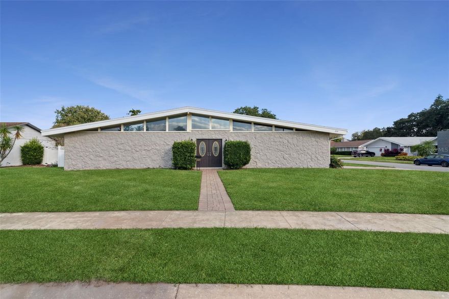 Discover timeless elegance and modern comfort in this stunning Mid-Century Modern home, beautifully situated on a corner lot in desirable English Woods—just a short walk to the elementary school. A pair of double front doors opens to a large formal entry that sets the tone for the home’s spacious design. Enjoy formal living and dining rooms, high vaulted ceilings, and neutral colors that create a bright, open atmosphere throughout. The home features newer NuCore waterproof laminate flooring, adding both beauty and durability. The large kitchen is a chef’s delight with stainless steel appliances, including a three-door refrigerator, Jenn-Air glass cooktop and oven, built-in microwave, handsome tile backsplash, and a cozy eat-in area. A large inside laundry room adds convenience, while the two-car side-entry garage provides ample parking. The primary suite offers a peaceful retreat with a vaulted ceiling, walk-in closet, and an adjoining sitting room, nursery, or office. Step into the expansive Florida room for extra living space or out to the sparkling pool with brick paver deck and roll-out sun shade awning, perfect for entertaining. The privacy-fenced yard features a double gate entry ideal for boat or RV parking, plus a storage shed for all your extras. Solid block construction offers lasting quality, style, and functionality—all in one exceptional package.