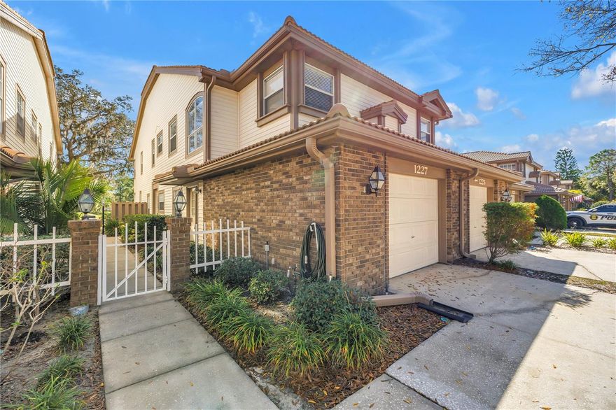 Take advantage of ideal market timing with this low-maintenance, townhome-style condo offering serene pond views in the highly desirable East Lake Woodlands community—a gated enclave known for its beautifully maintained homes and lush Florida landscaping. Located on the second level, this residence features a private courtyard entry leading to stairs that open into an expansive, light-filled floorplan. The layout includes two generous living areas—a formal living/dining space and a versatile family room adjacent to the kitchen. The formal living area features wood flooring, a wood-burning fireplace, and sliding doors that open to a screened lanai overlooking the tranquil community water feature. Vaulted ceilings add an airy, open ambiance throughout. The spacious primary bedroom includes wood flooring and a stylish barn door that leads to the ensuite bath and walk-in closet with custom closet organizers. The bathroom is well appointed with a double vanity, soaking tub, separate shower, and a private water closet. A comfortable guest bedroom has convenient access to a full bath with a tub/shower combo—ideal for visitors. Additional highlights include an indoor laundry closet with full-size Samsung washer and dryer. The kitchen offers lots of counter space and cabinet space, granite countertops, Bosch dishwasher, a center island with glass cooktop and vented hood, and flows seamlessly into the family room/flex space—perfect for an office, den, or guest area. An attached garage features built-in storage cabinetry. Major updates provide peace of mind: tile roof replaced in 2021 (covered by HOA), HVAC replaced in 2017, and water heater replaced in 2025. Professionally painted in 2025, the interior offers a crisp, clean backdrop for your personal style. The monthly fee covers exterior building maintenance, roof replacement, groundskeeping, cable, water, and trash removal. A heated community pool for residents is available year round. Small pets are welcome, and rentals are permitted with approval (up to three times per year, 30-day minimum). Residents may also join the optional East Lake Woodlands Country Club to enjoy two Championship 18-hole golf courses, 14 HAR-TRU tennis & pickleball courts, fitness facilities, and social activities. The community offers exceptional convenience to the Pinellas and Oldsmar trail systems, shopping, dining, Tampa International Airport, and the world-famous beaches of Caladesi and Honeymoon Island—perfect for embracing the year-round Florida lifestyle.