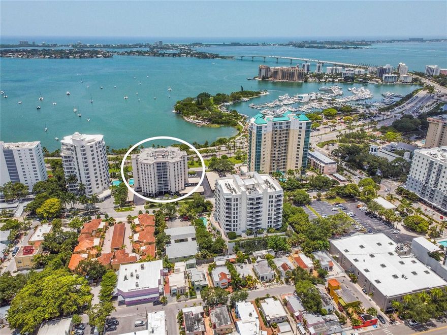EXCEPTIONAL PRICE… Experience downtown living in a prime Sarasota location just moments from the bayfront, restaurants, galleries, and cultural attractions. This spacious 2-bedroom, 2-bath residence offers 1,705 sq. ft. of thoughtfully designed comfort and style. The unique split-bedroom floor plan provides privacy for both owners and guests, while the generous great room creates an inviting space to relax or entertain. Step into the enclosed lanai and take in captivating and expansive city and bay views which provide the perfect backdrop for morning coffee or a relaxing evening. The modern kitchen showcases quartz countertops, wood cabinetry, and stainless-steel appliances.  And the living space was thoughtfully enhanced by creating a dedicated home office with built-in shelving, filing cabinets and lighting that offer a quiet retreat for work or creative pursuits. With excellent storage throughout, this residence is ideal for full-time or seasonal living. Residents can enjoy the peace of mind that comes with a well-managed building, featuring an onsite manager and 24-hour concierge service. Management is always quick to respond with a recently added 2 ft. flood barrier for added protection. Residents also have access to an array of amenities, including a heated pool, grilling area, bicycle racks, fitness room, library, and social room. Situated on a quiet and serene tree lined street, this downtown Sarasota residence captures the essence of urban sophistication with coastal charm.