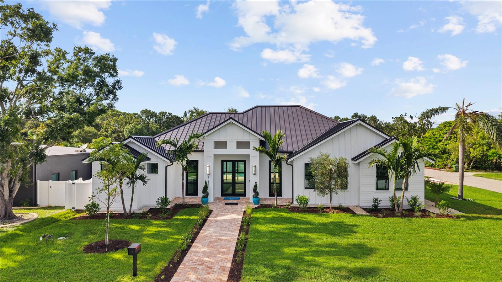 Welcome to 1915 Tulip Drive – a beautiful Single Story home you will love!
This just completed Modern Coastal Single Story home is located West of the Trail in the preferred Zone X (unshaded) with elevated storm protection and easy access to Siesta Key beaches, Southside Village and Downtown Sarasota.
Built strong and stylish by Majestik Homes, this 4 bedroom 4 bathroom residence blends architectural elegance with energy efficiency and storm-ready construction.
From the moment you enter through the grand 9-foot doors, you’re greeted by soaring ceilings, expansive glass, and a seamless indoor-outdoor flow that captures Florida living at its finest. The open floor plan centers around a designer great room, a chef’s kitchen outfitted with premium Thermador gas appliances and a dining room that is perfect for intimate dinners and larger gatherings.
Designed with both performance and sustainability in mind, this home features energy-efficient lighting, appliances, and insulation systems that reduce consumption without sacrificing comfort. With 2 efficient air conditioning units and a tankless gas water heating system you will enjoy energy efficient heating and cooling year-round.
Built with an emphasis on strength and safety, this residence offers peace of mind with a finished floor height of 26’ above sea level and materials selected to withstand Florida’s toughest storms. Every detail—from the block construction to the impact-rated windows—has been thoughtfully engineered to provide long-lasting security and a safe haven for your family.
Beautifully staged and thoughtfully designed, this home showcases artwork from some of the local area’s most inspiring artists. Easy to show – you won’t want to miss this exceptional opportunity