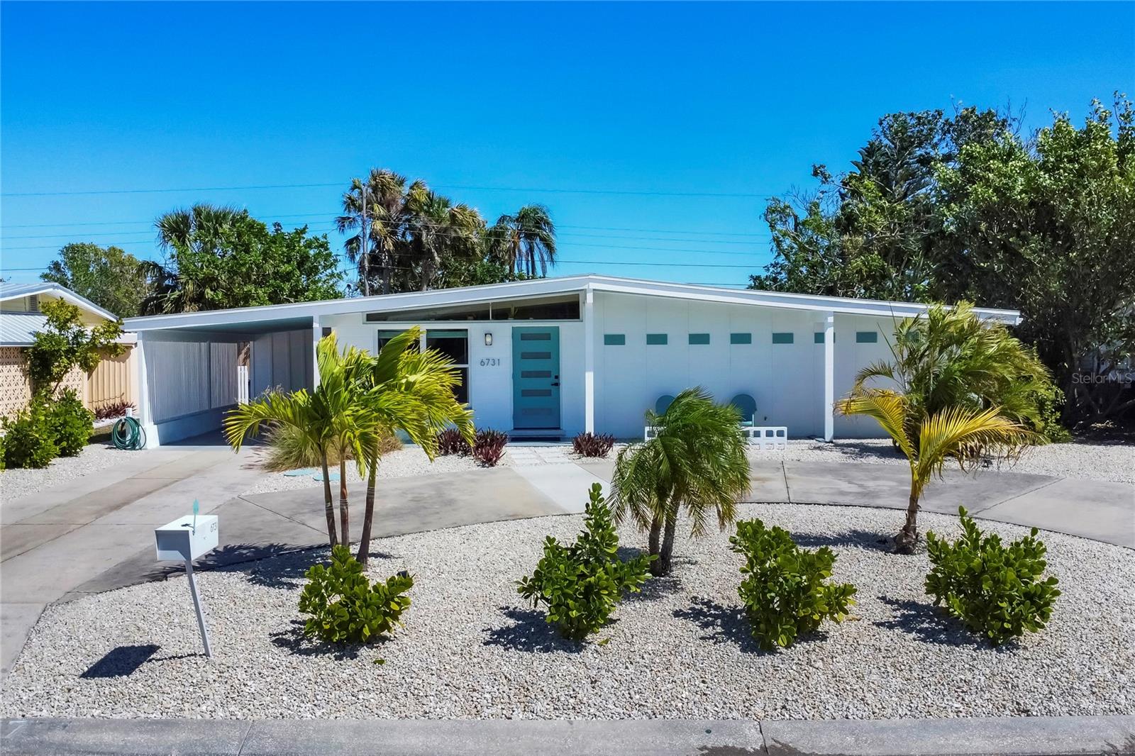 Finance with as little as 5.875% INTEREST RATE w/acceptable credit. Seller offering to pay 1 1/4% to buy down a buyer's interest rate, hence lowering the payments to permit qualifying for more! This mid-century gem enjoys nearby Sarasota Bay breezes. Welcome yourself to a tastefully updated & lovingly maintained 3-bedroom 2 full bath West Bradenton home that is sure to please. The sellers have a unique knack for embellishing on the characteristics of an era gone by, starting w/the refinished terrazzo floors & ending w/the beamed & vaulted ceilings above & everything in between. The kitchen was tastefully updated in 2023 w/quartz counters accompanied by a pretty tile backsplash, beautiful wood cabinets, large pantry, stainless appliances & those ever-popular pan drawers. An abundance of storage is found in the lazy Susan corner cabinet as well as the large island which is home to a smooth cooktop w/a warmer burner & plenty of room for bar stools. The dining area is light & bright w/a full wall impact window & is home to a charming hanging retro light. A spacious living room has sliders to an awesome screened lanai that leads outdoors to a well-manicured side & back yard. The rear walkways have been updated w/stone & concrete patios for year-round enjoyment leading to the beautiful backyard w/its lush green grass, a Meyer lemon fruit tree & tropical Christmas palms. Back inside the lucky new owners of this awesome home will enjoy a spacious primary bedroom w/a mini-split AC unit (for those of you who like to sleep w/a blanket) & impact sliding doors that lead to the backyard oasis. The primary bath has a thoughtfully designed décor w/spa tile floor & shower wall, step in shower, floating vanity, light up mirror & textured glass door that aligns beautifully with the period style motif. The guest bath enjoys the same mid-century-like genre w/a European style bowl & vanity w/a vessel sink, coordinating w/the original tub which is complimented by an updated shower head & glass. A covered carport is accessed via a large circular driveway for overflow parking & houses a spacious laundry & storage room. The outside front has been given the same attention to detail w/its tropical color palette, retro style textured glass front door, raised house numbers, all encompassed by the beautiful Florida fauna & decorative stone. Other notable features include a 2023 roof, updtd plumbing & electric panel, baseboards & door jambs, 6 panel interior entry doors, gutters, ceiling redone w/newer insulation & faux beams, lighted ceiling fans, dedicated storm plywood for bedroom windows & central AC. Bayshore Gardens enjoys a plethora of amenities including a junior Olympic pool, community clubhouse, baseball field, basketball court, playground, picnic tables, & kayak launch, most of which is included in the annual Recreation District Tax. In addition, there's a huge marina w/boat dock & dry storage for nominal fees compared to commercial spaces. Students enrolled in IMG Academy, SCF, Bayshore High or Elementary or Lee Middle Schools, are about 5-10 minutes away. Approx 10 minutes to SRQ Airport, Ringling Museum & Asolo Repertory Theater, 15 to 30 minutes to sugary sand beaches, UTC Mall, St. Armand’s Circle, restaurants, houses of worship, theaters including live plays, boating, golfing, fishing, rowing & sports teams incldg springtime professional baseball, & polo matches. Come enjoy the ambiance of this wonderfully updated period style home before it is gone.