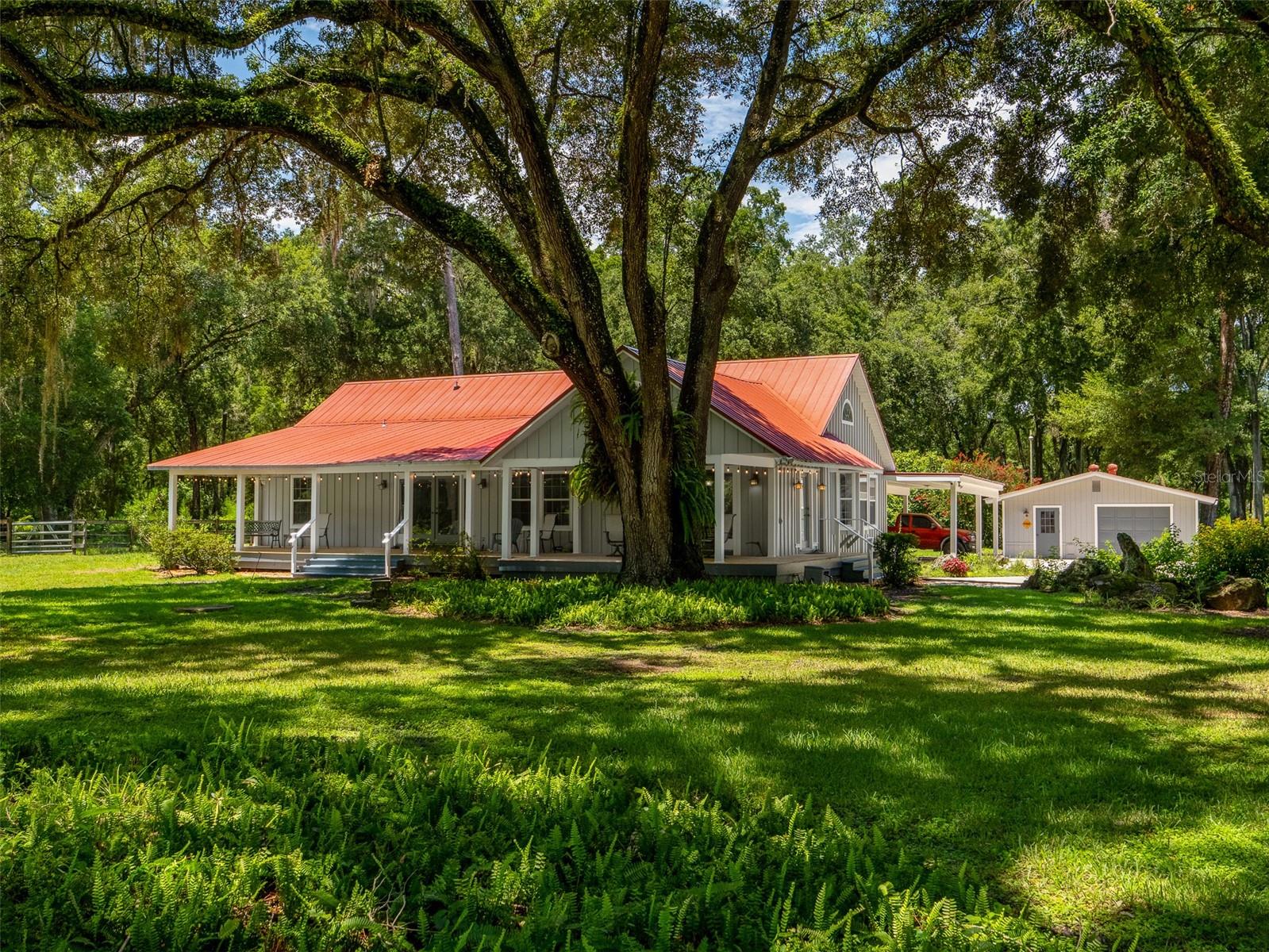 Don't miss this incredible opportunity to own a versatile and private property featuring a 3 bedroom, 2 bathroom main home plus a 1 bedroom, 1 bathroom guest cottage – all set on over 12 fully fenced acres with gated entry! This property features 2 separate parcels. One parcel being 6.63 acres featuring the house, cottage and other outbuildings. The other parcel being 6.02 acres with its own 3" well, septic and clay electric power pole. Great for multi-generational living! Perfect for animal lovers, hobby farmers, or anyone craving space and serenity, this property includes fenced pastures and barns ready for livestock or horses. The main home welcomes you with a spacious covered front porch – ideal for sipping your morning coffee while taking in the peaceful surroundings. Inside, you'll find a bright, open-concept living room filled with natural light, along with three generously sized bedrooms, two of which offer private ensuite bathrooms. A large bonus room makes a great home office, playroom, or studio space. Step outside and into the separate 1 bed / 1 bath guest cottage, perfect for visiting friends or extended family. Additional features include a Detached 2-car garage – ideal for a workshop, vehicle storage, or recreational gear, a water treatment/sediment filtration system – enjoy ultra-clean, fresh water, a gated entry and full fencing – privacy, security, and peace of mind. This rare gem offers endless possibilities and won’t last long. Schedule your private showing today! Metal roof (2013) and roof was rescrewed to deck in 2022 to meet new codes. Both AC's replaced in (2022), water heaters replaced in (2022), drain field replaced in (2023), new 4" deep well and pump with a 100 gallon pressure tank installed in 2022, whole home complete filtration system including a sediment filter installed in 2024 and cottage septic pumped in 2021.