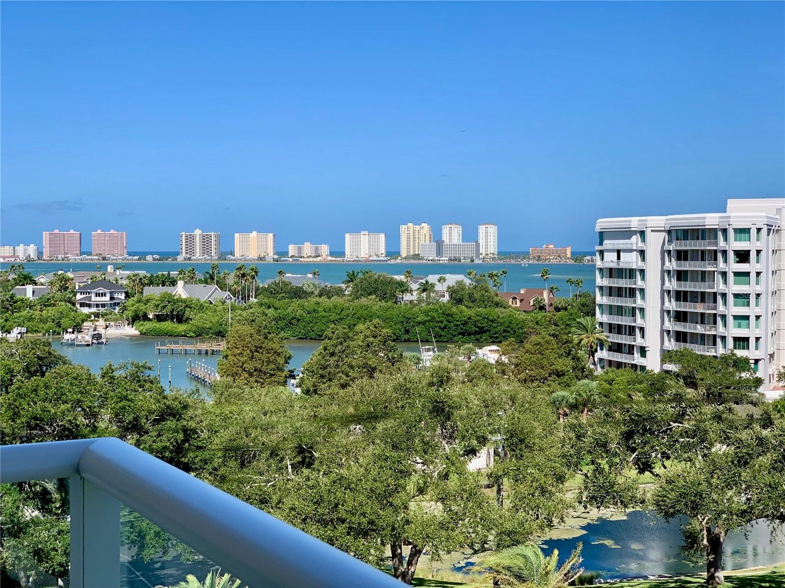 One or more photo(s) has been virtually staged. Experience unparalleled, luxury living at The Residences at Belleview Place, behind the guarded gates of the Belleair Country Club. Upon entering, this fifth-floor residence, you will be greeted by breathtaking, panoramic water views of the intracoastal waterway and the Gulf of Mexico as well as serene views of the Belleview Place gardens, Belleview Inn and pool. This home is bathed in an abundance of natural light. Lofty ceilings highlight the elegance, openness and spacious luxury of this private estate in the sky. The living room features a wide expanse of bay windows which frame vibrant sunsets over the Gulf. The gourmet kitchen is a chef's dream. It features top-of-the-line stainless steel, Jenn-Air appliances, Cambria granite countertops and ample storage space in the custom cabinetry. Completing this space is a dining nook with sliders which open onto a private terrace which is perfect for al fresco dining with its calm, sea breezes. The condominium features two spacious bedrooms, each with its own ensuite bathroom. The primary suite is a tranquil retreat, featuring a private balcony, a spacious walk-in closet with custom built-ins, and a spa-inspired bathroom with jetted, chromotherapy tub. The secondary bedroom features plantation shutters that open onto the main balcony. Additional features of this home include a charming powder room off of the foyer and a spacious laundry room with a deep utility sink, cabinetry, and stacked washer and gas dryer. In addition to these luxury finishes, there is impact glass throughout the home, offering peace of mind during the summer storm season. There are two, under building assigned parking spaces in a secure garage as well as a storage unit. This condominium has all the elements of luxurious Florida, where it sits atop a 35-foot bluff in the highly sought after and exclusive Town of Belleair. Residents of Belleview Place enjoy an array of amenities including a resort style swimming pool and access to membership at the Belleair Country club, Florida’s oldest private golf club which offers 36 holes of championship golf, pickle and tennis ball courts, croquet lawn, state-of-the-art fitness and aquatic center, spa, and fine dining. Don't miss this opportunity to own a piece of Belleair's charm.