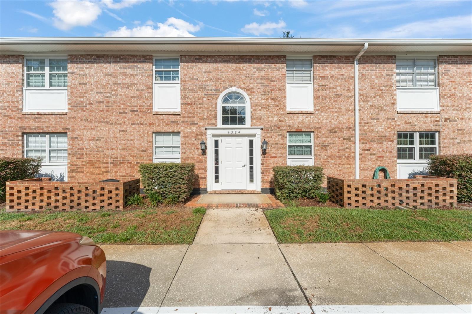 **This house comes with a REDUCED RATE through the seller's preferred lender. This is a lender-paid rate buydown that reduces the buyer's interest rate and monthly payment.** Welcome to this charming 2-bedroom, 2-bath first-floor condo located in a desirable community on Lake Underhill. As you enter, you're greeted by a galley-style layout that opens to a spacious living area with French doors leading to a screened-in porch—perfect for enjoying the peaceful, shaded views of the grassy open space and mature trees just beyond. To the left of the entrance, the open-concept dining area flows into a bright kitchen featuring a front-facing window, white cabinetry with crown molding, and stainless steel appliances. Down the hallway, nestled between the living and dining spaces, you'll find both bedrooms and additional storage. The primary suite is located at the rear of the home and offers a walk-in closet and an ensuite bathroom complete with an extra-long quartz vanity, a framed mirror, and a tub/shower combo. The second bedroom sits across the hall, conveniently next to the second full bathroom. A dedicated laundry room with washer/dryer hookup is also located off the hallway for added convenience. Step outside to enjoy the tranquil screened-in porch with direct access to the landscaped common area between buildings—ideal for relaxing or enjoying a morning coffee. This well-maintained condo is the perfect blend of comfort, function, and location. Schedule your private tour today!