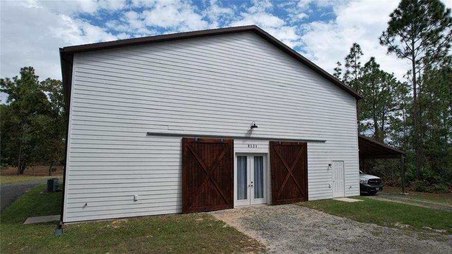 Enclosed Barndominium on 5.09± Acres in Wildwood Country Estates – Built in 2017
Discover the perfect blend of country living and functional design with this enclosed Barndominium set on 5.09± private acres in desirable Wildwood Country Estates. Built in 2017, this unique property offers flexibility, space, and endless potential for expansion.
The home features 2 bedrooms, an office, and an upper living area of 800 sq. ft. The bedrooms are ready for your personal touch—simply frame in closets to complete the spaces. Above the garage, there is ample room to expand the living area even further with minimal structural modification, allowing you to customize this Barndominium into your ideal layout.
Car enthusiasts and hobbyists will appreciate the impressive 2,600 sq. ft. garage/workshop, offering oversized enclosed space for restoring cars, storing multiple vehicles, and keeping tools and equipment organized. An additional 832 sq. ft. carport provides shaded parking for RVs, boats, and trailers—perfect for anyone needing abundant storage options both indoors and out.
With no HOA, you have the freedom to use the land and space as you choose. The acreage offers privacy, room to expand, and the ability to create the lifestyle you’ve envisioned.  Don't miss this rare opportunity to create your own dream retreat regarding an enclosed Barndominium and five acre homesite!  This property is minutes away from shopping, restaurants, outdoor dining and The Villages.  Hurry to see and welcome home!!