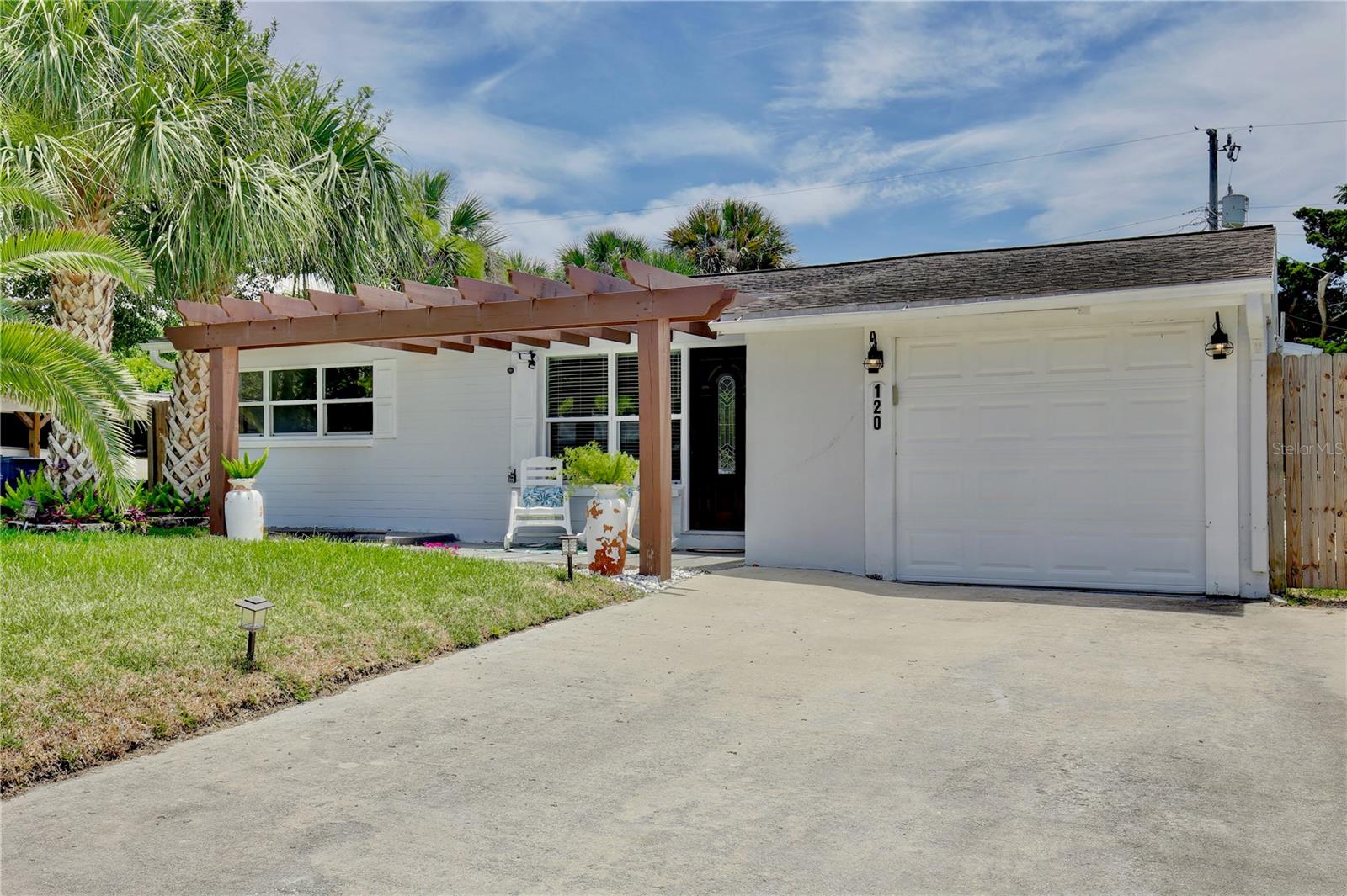 AVAILABLE FOR RENT! Experience coastal living at its finest in this charming haven, where you’ll be walking distance from public beach access, fishing piers and riverside parks—tailored for those who dream of a life by the water. Presenting a cheery exterior complemented by a pergola framed entrance, this home welcomes you to beachside bliss. Step inside this FULLY FURNISHED BEACH HOME to discover an open and airy floor plan that exudes warmth and style, with wood look vinyl floors and a harmonious palette of neutral colors throughout. The rustic light fixtures add character, while the living room draws you in with its wood panel TV accent wall featuring a cozy electric fireplace. The living space flows seamlessly into a dining area boasting built in booth seating, perfect for gathering with friends and family. Enjoy cooking family favorites in the light and bright kitchen, equipped with lustrous granite countertops and stainless steel appliances. Your private retreat awaits through French doors in the primary bedroom, offering serene views of the tropical backyard. Across the hall, the modern bathroom showcases a sleek glass door shower and stylish vanity. Guests will feel right at home in the spacious and welcoming bedrooms, while the second bathroom features a classic tub/shower combo and chic beadboard paneling. The laundry room completes the interior with a Whirlpool washer and dryer, ample cabinet space, and wooden floating shelves. Your personal tropical oasis awaits outdoors, featuring a covered paver patio with ceiling fans and enchanting lantern lighting. Follow the stone walkway to a cozy hammock corner, perfect for summer grilling and relaxation. The fenced yard is an ideal playground for pets and outdoor activities. Situated just steps away from Publix, dining, and leisure at Argosy Park with beach access, and also less than a mile from public fishing docks and parks on the Halifax River, this home combines the serenity of beach living with the convenience of nearby amenities. Spend the weekends fishing, boating, and soaking up the Florida sun.