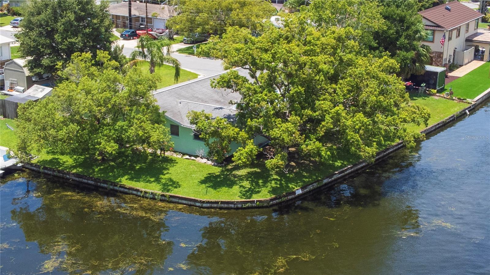 Classic Florida living in desirable Lake Shore Estates! This unique canal-front home, built in 1958, sits on a rare double lot (approx. 0.31 acre) at the end of a cul-de-sac with direct access and left facing view to Lake Tarpon — Pinellas County’s largest freshwater lake. Enjoy peaceful canal frontage with a serene backyard setting.
Stainless steel appliances are in the kitchen. The layout includes 5 bedrooms, with one currently used as a workout room/office featuring a built-in corner desk. The primary bedroom originally had sliders that opened to an enclosed porch, which has since been converted into the family room and two additional bedrooms — offering extra space and layout options to fit your needs. There’s a living room with a built-in Murphy bed, plus an open dining room adjacent to the family room. All window treatments convey except the rods and blackout curtains in the primary bedroom. A 12x24 shed (permitted) conveys, along with the gazebo and shade covers.
The 1-car garage has a storage room at the back and the garage itself houses the laundry hookups plus a utility sink. While buyers should plan for unfinished projects — this home is ready for your updates. A carport is situated on an easement and was grandfathered in by the previous owner many years ago, per Seller, as well as plumbing/sewer line replacement from the house to the street.
Outdoors, the left side of the property (Lot 33) is where the home sits and has approximately 115' of freshwater canal frontage to the east; the right side (Lot 34) is the adjoining vacant lot and has approximately 148' of canal frontage, providing extra storage, privacy, or room for toys and garden projects. Both lots are combined under one deed (property records show a total of 13,534 sq ft). The yard features fruit trees that have not yet began producing. A wood fence partially encloses the vacant lot side to keep storage neat and tidy (no gate, not fully fenced in). Property includes a manual crank boat davit (condition and lift capacity unknown), a small wood observation deck (added 1996, condition not warranted), and a seawall estimated at 50 years old, constructed of railway ties — also not warranted or guaranteed. The canal supports shallow-draft recreational boating typical for Lake Tarpon. Acceptable boat types may include pontoons, small flats boats, skiffs, Jon boats, and kayaks.
Updates, per the Seller, include a metal flat roof (maybe 4 years old?), carport roof reshingled in 2025, some double-pane windows installed in 2011, a Rheem water heater (2018), and a 200 amp electric panel (date of upgrade unknown). The Seller let us know that the property is on well water; the septic tank was reportedly removed or filled by a previous owner many years ago when they converted to public sewer. Two bedrooms were added from an enclosed porch area — you step down into these rooms. Bedroom 2 at the front includes the start of what was to be a walk-in closet from an enclosed porch.
Enjoy Old Florida charm, boat-friendly lifestyle, mature landscaping, and fruit trees in one of Palm Harbor’s beloved waterfront communities. Bring your vision and make this classic canal-front gem your own! The property has cameras with audio/video capability (do not convey). All information provided is deemed reliable - must be verified by buyers and their representatives. Inspections & flood insurance are recommended and may be required by a lender.