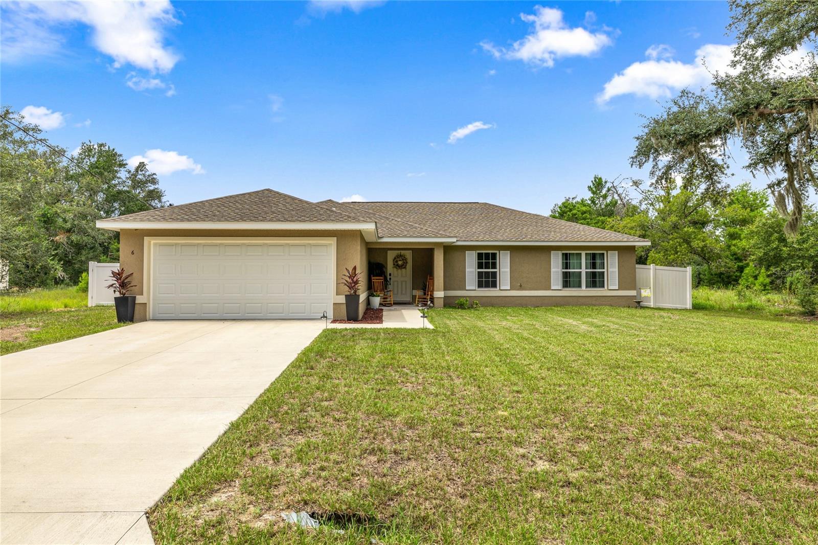Step into the perfect blend of comfort, style, and convenience with this beautiful 2023-built 4-bedroom, 2-bathroom home offering just under 1,800 sq ft of living space. The sought-after triple split floor plan allows for both privacy and connection, making it ideal for families or anyone who loves to entertain. The spacious primary suite is a true retreat, featuring dual sinks, a large walk-in closet, and a relaxing shower/tub combo. Every detail has been thoughtfully designed, from the brand-new vinyl privacy fencing with oversized gate to the whole-home water filtration system for peace of mind. Tucked away on a private street with no current neighbors, this home offers a rare sense of seclusion while still being just minutes from everything you need. Imagine weekends at nearby Eaton’s Beach or Gator Joe’s, or exploring the endless outdoor adventures of the Ocala National Forest—all within easy reach. With quick access to Ocala, Belleview, and The Villages, this home combines the tranquility of nature with the convenience of city living. All that’s missing is you!