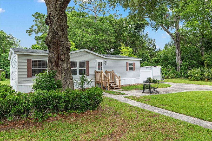 Pride of ownership shows in this well-maintained home that is 100% move-in ready! Tucked away on a spacious corner lot shaded by majestic oaks, this 2002 built mobile home offers privacy and convenience with easy access to shopping, restaurants and historic downtown Newberry. Recently updated, this doublewide features 3 bedrooms, 2 bathrooms and almost 1,200 square feet of comfortable living space on nearly half an acre of land. Step inside to discover a spacious living room with direct access to the eat-in kitchen. The kitchen features generous storage, expansive counter space, and updated stainless steel appliances. Located just off the kitchen is the dedicated laundry area featuring top of the line washer and dryer. The generously-sized primary suite is a peaceful retreat, offering multiple windows for natural light, a walk-in closet, and a spacious en-suite bathroom complete with a walk-in shower. Two additional bedrooms provide flexible space for guests, a home office or workout room. Most major systems in the home were replaced/upgraded approximately two years ago to include roof, HVAC and plumbing (now PEX).  Take advantage of Florida's year-round weather under the shade of mature hardwoods and citrus trees and have plenty to space to grown your own garden! Just few blocks from the newly built Publix in Newberry and just minutes from an exciting mix of new dining and retail options, this property is ideal for those who love having everything close to home!