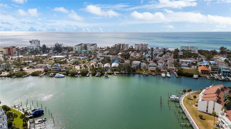 This Coastal Home is a boater's dream in a protected Lagoon on the Intracoastal Waterway with direct access to the Gulf of Mexico. The Key West Style home is wrapped in porches, capturing salty breezes for an endless vacation vibe. This waterfront beach house is found on a corner lot with both sunrise and sunset views. An open floor plan includes a living room with built in shelving for media, entertainment and personal treasures. The dining area provides a large gathering space while the kitchen has a center island with breakfast bar, open shelving for glassware, a wine nook, and a large pantry for storing dry goods and small appliances. Sand colored granite countertops float above white shaker cabinets with abundant prep and storage space. Take indoor living outside through sliding doors to the covered waterfront living area. All on one living level, the Primary Suite has French doors to the westward porches to delight in sunset skies and nightcaps. The ensuite bath has been updated with large vanity and a gorgeous, tiled steam shower. No need to share a closet, you can each have your very own! The second bedroom also has French doors to the sunset porch to let in the natural light. The third bedroom offers flexibility for residents, guests or a home office. This Custom home has gorgeous eucalyptus flooring and 9’ ceilings throughout, 6” crown moldings, thoughtful built-in features, designer hardware and fixtures – this is a truly special home. While the living area has ample storage space, there is also a large garage with room for several vehicles, golf carts, bicycles, beach toys and fitness area. Take your kayaks and paddleboards right out the back door. The waterfront has a deep-water dock with power, water and even an outdoor shower. Sailboat water, in a no wake zone, has direct access to the Gulf of Mexico via John’s Pass. The back yard oasis has a covered lanai for BBQ and al fresco dining or chilling out in the shade. Tropical palms surround the space for privacy, leaving room for a pool. Beach access is just two blocks away with a crosswalk at Gulf Boulevard and 123rd Avenue. Custom built in 2016 at 14’ above sea level, this home is a fortress, exceeding FEMA requirements with impact glass windows and doors, metal roof, and reinforced engineering. This home is offered fully furnished, Move-in Ready with Motivated Sellers!