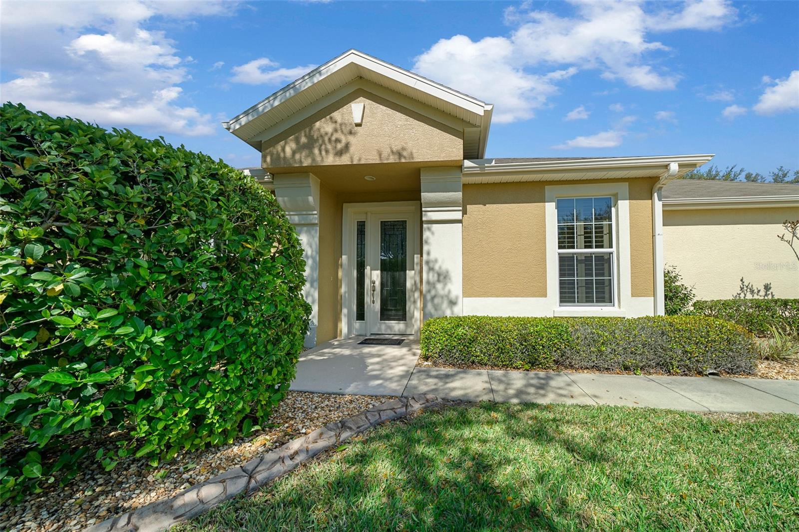 Private golf course views located in Del Webb Stone Creek. This stunning Augustus Villa includes 2 bedrooms, 2 bathrooms, a flex room with doors, and a 2-car garage. The villa has been tastefully remodeled. Upon entering the front foyer, you will find the flex room to the right, featuring glass doors, 2 windows, and a light/fan combination. Next, you will enter the spacious living area, which boasts a modern kitchen equipped with a stackable oven/microwave, a wine fridge, updated functional cabinets with built-ins, under-cabinet lighting, illuminated glass cupboards, and quartz countertops with neutral backsplash. Kitchen opens to the spacious living room for seamless entertaining. The lanai has been enclosed, adding an extra 200 sq ft of living space with a picturesque view of the water and golf course. The primary bedroom features 3 large windows with a view, recessed lighting, a ceiling fan with light, and a walk-in closet with built-in organizers. The primary bathroom has been remodeled to include a large double vanity, separate mirrors, a custom shower with a fold-down seat, and a linen closet. As you return to the main living area, the backyard view impresses with large glass doors leading to the screened and roofed porch with pavers, allowing you to enjoy the private views of the landscaped surroundings. The laundry room is equipped with cabinets and a utility sink. This home also includes plantation shutters throughout, a water softener, garage overhead storage racks, gutters with gutter guards, and LVP flooring throughout. Your HOA fee covers lawn, shrub, and tree maintenance, a master insurance policy for the exterior, roof replacement/repair, exterior painting, irrigation system maintenance and repair, water for lawns and landscaping, internet, and amenities. Del Webb Stone Creek is an active 55-plus community that offers a fitness center, spa, golf simulator, pool, basketball court, dog park, pickleball, softball, tennis, a heated resort-style pool, walking and bike paths, and a catch-and-release fishing pier. For additional fees, a golf course, grill, and café are available on-site. Don't miss out on this opportunity!