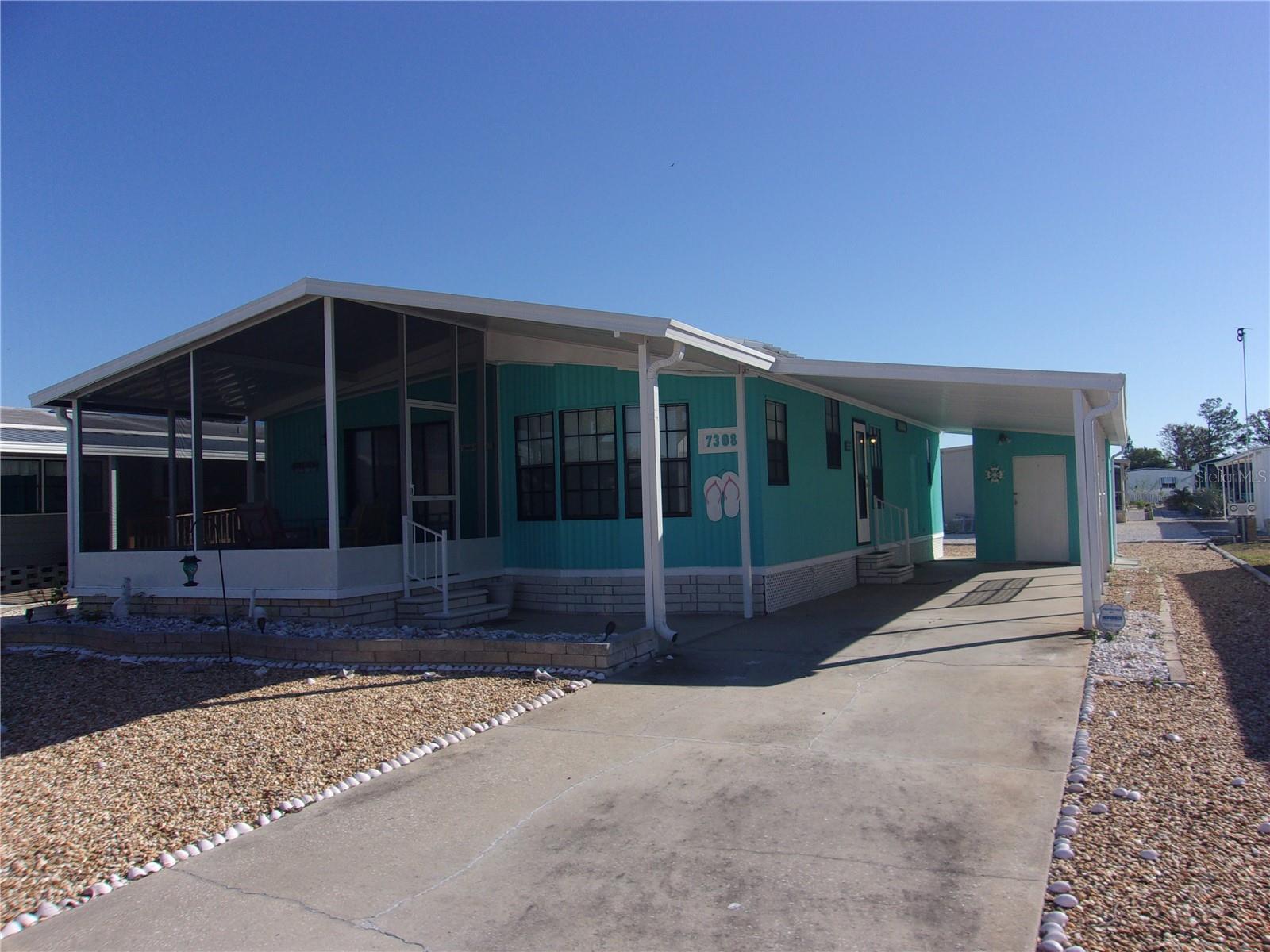 Cute and cozy doublewide mobile in awesome Ponderosa Park! Wow, this home shows off pride of ownership and a great modern Beachy Vibe. Two large bedrooms, the Primary Suite features a full bath with shower, lots of closet space and ample room for the King Sized Bed! A roomy second full bath is there for guests, and is near the Guest Bedroom for convenience. Open Living area with beautiful luxury laminate floors, dining room and kitchen invites dinner parties and entertaining. Enclosed screened Front Porch is a great place to relax, and offers more space to chill. Large and convenienient Shed/Workshop is where you'll find the laundry, and the gravel yard is easy to care for. Best of all, this home comes furnished down to linens and dishes, even the decor remains!! In Ponderosa Park, you own the land, and the HOA fees are only $250/yr that includes beautiful Clubhouse and awesome Community Pool, as well as Bocci and Shuffleboard. Truly move-in ready and packed with value.