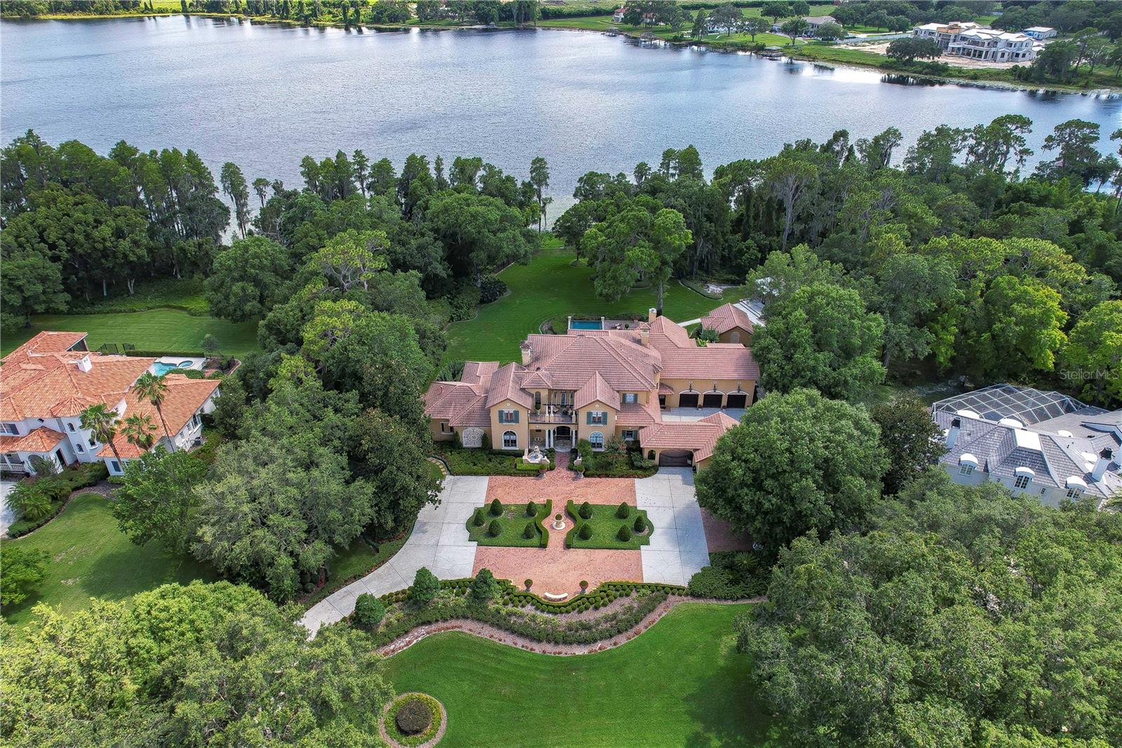 Welcome to the epitome of luxury lakefront living! Nestled within the distinguished guarded, and gated community of Stillwater, this remarkable estate spans over 2.5 acres of pristine land, offering a serene and exclusive retreat for the discerning homeowner. Boasting an impressive, heated living space of nearly 8,900 square feet, this exquisite residence showcases unparalleled craftsmanship and meticulous attention to detail. As you step inside, you'll be greeted by soaring ceilings that create an airy and grand ambiance, while the abundance of windows invites natural light to illuminate every corner of the house. Designed for ultimate comfort and privacy, this estate features five spacious ensuites, including a luxurious downstairs master suite and a guest bedroom. The master bedroom is further enhanced by the presence of a private fireplace and his-and-her vanities, providing a true sanctuary within the home. Both the family room and Living room also feature their own fireplaces. With a total of seven full bathrooms and two half baths, every convenience has been thoughtfully provided. Additionally, apart from the main kitchen, there is a well-equipped prep kitchen, accompanied by a massive laundry room for your convenience. An additional laundry room can be found upstairs, ensuring effortless housekeeping. Entertainment is taken to new heights with the inclusion of a media room, bonus room that can be large bedroom it has full bathroom & closet, craft room, and gym, catering to all your recreational desires. Need a space for work or study? There's a dedicated office for your professional needs. Upstairs you will find 3 additional ensuites, with one of those having a large sitting area, practically large enough to be another bedroom, that allows for privacy and relaxation. Embrace the captivating lake views and enjoy direct access to the water with your own private dock, complete with a convenient boat lift. The outdoor oasis beckons with a sparkling pool and spa, accompanied by an outdoor kitchen for delightful al fresco dining experiences. The meticulously manicured landscaping provides an enchanting backdrop, creating a tranquil and picturesque setting. This estate truly has it all, including a climate-controlled 5-car garage that showcases sub zero refrigerator/freezer, cooktop range with vent, exquisite cabinetry for storage, ensuring your vehicles are kept in pristine condition. To further enhance convenience, a bathroom is conveniently located within the garage. In the event of power outages, a generator stands ready to provide uninterrupted comfort and peace of mind. No detail has been overlooked in this remarkable lakefront haven, where luxury and elegance meet at every turn. Don't miss the opportunity to make this lakefront estate your own and experience the pinnacle of luxurious living.