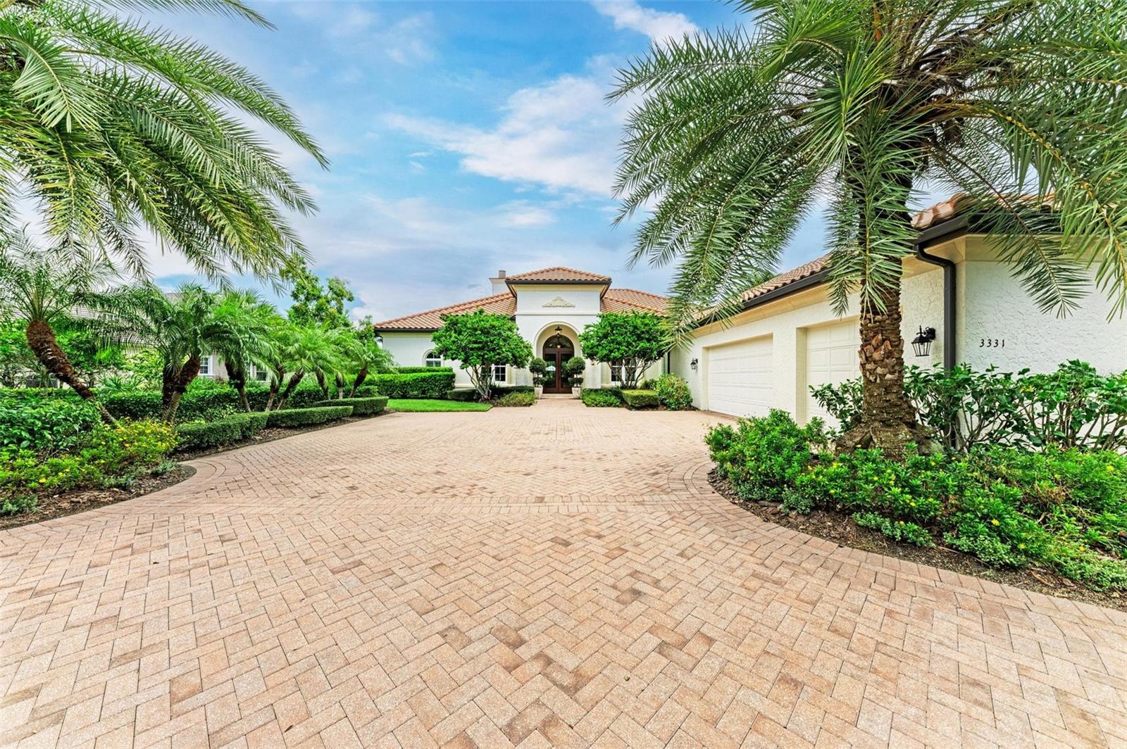 Magnificent custom London Bay home with sweeping views, elegant architectural details, and gorgeous design features. Simply a must-see for those seeking the Founders Club lifestyle. Come home to a private sanctuary and incredible sunsets each evening set against the backdrop of the 16th fairway.
Situated on a prime homesite with over 1/2 an acre of land with stunning golf, preserve, and lake views. The exterior of this home is timeless and enhanced with mature landscaping and a semi-circle driveway. The handsome double door entry leads to a sunlit foyer and living room with soaring ceilings. The lovely single-story layout is open and offers connected main living spaces for gathering with seamless indoor and outdoor living. The well-appointed primary suite shares a wing with a private study. On the other side of the home, the spacious guest suites offer privacy and separate bathrooms. A showcase gourmet kitchen with solid wood cabinetry, double oven gas range with decorative hood, and ‘Taj ‘Mahal’ natural quartzite stone is perfect for a home chef and entertaining. A butler’s pantry offers additional storage with a sink and prep area. Superb construction quality including impact glass, solid core doors, genuine satin travertine flooring, exposed wood beams and much more. The outdoor living is spectacular with a luxurious colonnade screen enclosure, a deep covered lanai, beautiful pool and spa, and an extended sun deck off the guest suite. This home is priced far below reproduction cost and must be seen to be fully appreciated. The Founders Club is in non-flood zone X, minutes to Lakewood Ranch and downtown Sarasota, with easy access to farmers markets, shopping, fine dining, theater, and world class beaches. The prized Robert Trent Jones Jr. course is the only walkable course in the region, and members enjoy easy tee-times. Social and golf memberships optional. The community offers Har-Tru tennis courts and a clubhouse with fitness center and restaurant with veranda. Come tour this home and discover an exceptional residence and lifestyle.