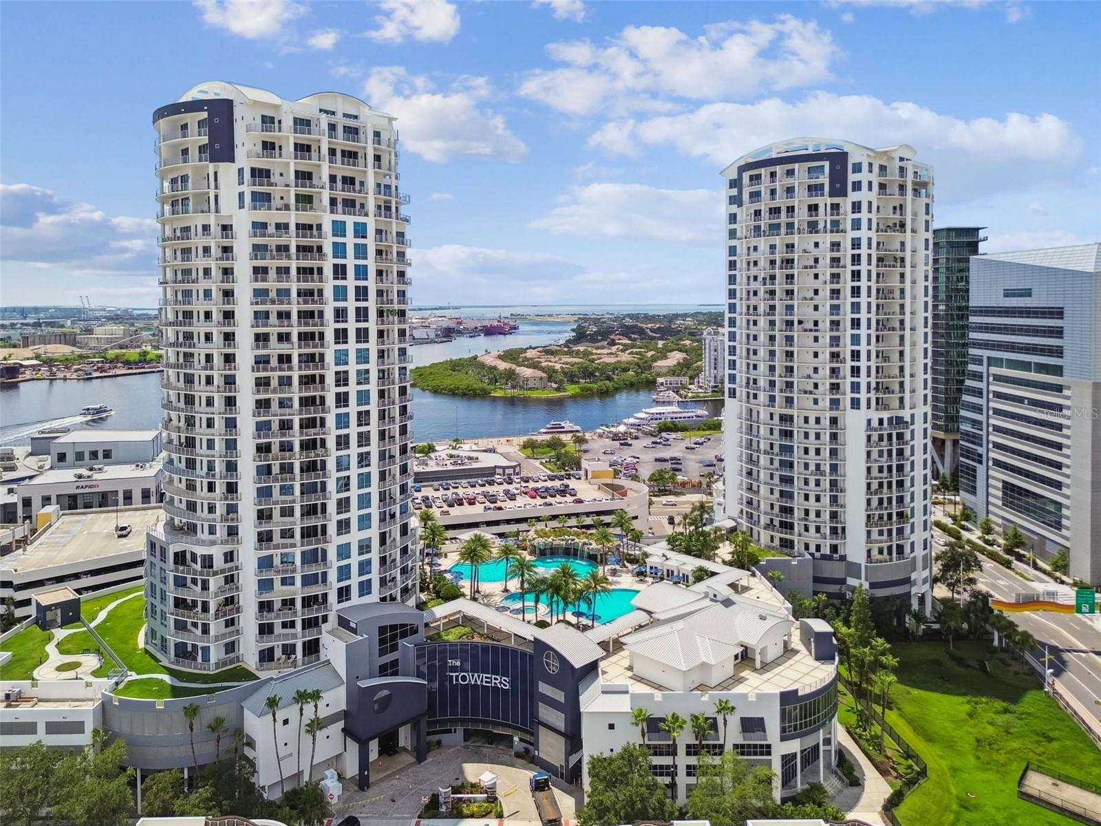 STUNNING views of Downtown skyline and Tampa Bay from every room and the expansive balcony! Gorgeous modern marble like tile throughout. Newer cabinets in kitchen with new KitchenAid appliances and a beverage cooler. Both bedrooms have ensuite bathrooms and large glass sliders to the balcony. The master suite has downtown views, two closets, dual sink vanity, large walk-in shower and separate tub. Bedroom windows have custom window treatments. Custom light fixtures. New water heater. Utility room has space for a side-by-side washer and dryer. Interior was just painted. The Towers of Channelside is getting some improvements including new lobbies on the ground level for each tower, a sauna, a fitness center and working space. A coffee shop and steakhouse will be opening on the ground level retail area. The Towers has 24-hour security with camera surveillance and a concierge desk for each tower. The amenities on the fifth floor include a resort style pool, a waterfall over a grotto, hot tub, grilling area, private dog park and a clubhouse for private events. The building is located across the street from Sparkman Wharf and Water Street. You can walk to the arena for hockey games and concerts, stroll down Riverwalk or even hop on the trolley to downtown or Ybor City. There are too many dining options to list that are easily accessible.