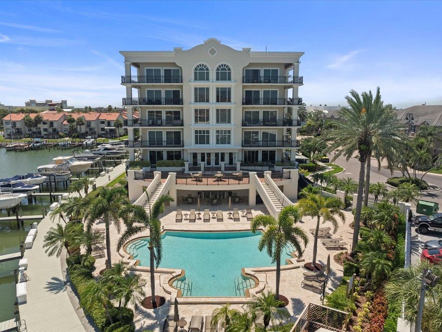TURNKEY totally remodeled 3 + study (currently used as a 4th bedroom) home located in the sought after waterfront community of Residences at Windward Passage at Island Estates!  This exquisite waterfront condo includes a DEEP WATER BOAT SLIP WITH A 16,000 LB BOAT LIFT, perfect for boating enthusiast! Step inside to this chef’s designer’s kitchen with Cambria quartz waterfall center island with Kohler apron sink and drop down Shades of Light modern lighting, Cambria quartz countertops and back splash, stylish under counter and floor lighting, Kitchen Craft modern European cabinetry with soft close drawers,  vibrant brushed modern brass fixtures, Delta Factory goose neck faucet, HIGH END GE Café appliances including French door convection oven and convection microwave, designer Café refrigerator, Zephr hood vent, and a tray crowned ceiling,  The spacious family room is an entertainer’s dream, showcasing engineered hardwood floors, art accent lighting, crown molding, Shade Store automated blinds and draperies, Shades of Light chandelier and quad 155 mph hurricane impact rated sliders leading to the oversized waterfront, tiled patio with picturesque views, The primary suite is a tranquil retreat with dual French door entry, tray ceilings, THREE CLOSETS (2 walk in) with Closets By Design custom closet systems, engineered flooring, Shade Store automated blinds/draperies and sliders to the lanai with serene water views, dream master bath with Cambria  Series 5” Quartz countertops, immense seamless glass shower with dual Kohler shower heads and Cambria Series shower walls and wall cladding, 69”  Gold Leaf, Desborough acrylic freestanding double slipper tub, Purist, modern brass faucets and Shades of Light chandelier, 2 ensuite bedrooms feature hardwood floors, custom shades, custom closet systems and 5 1/4” baseboards, guest baths are equally impressive and feature 5” Windsor Brass Satin Ridge Countertops, seamless glass enclosed showers with Satin Ridge walls (2nd ensuite offers a seamless glass enclosed tub), Kohler lighting and mirrors,  half guest bath with Serena and Lilly wallpapering, new Kohler lavatories throughout, Shade Store automated blinds and draperies throughout, Closet by Design custom closets throughout, Daikon AC and compressor (2024), newer hot water (2022), solid doors throughout! Residence amenities also include an exterior storage unit and 2 assigned under building parking spaces, oversized heated and COOLED salt water pool, 2 grill areas, under building bike storage and car wash area. The owners club room boasts a full sized bar area, billiards table, two large flat screen TVs, full kitchen and pool baths for your private parties. All Located just 2 minutes from the famous Clearwater Beach, this residence offers the perfect blend of luxury, convenience, and coastal living. NOTE: OWNER MAY CONSIDER A LOWER MONTHLY RENTAL AMOUNT WITH A ONE YEAR LEASE !!!!!