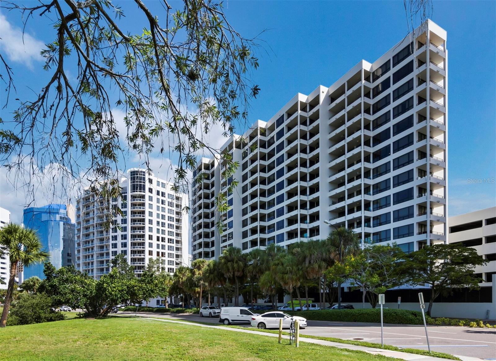 Elevate Your Lifestyle at Bay Plaza — A Rare Corner Gem in the Heart of Sarasota. Step into refined luxury with this expansive and elegant condominium in the highly coveted Bay Plaza. Perched on the 4th floor, this stunning corner residence offers sweeping views of the bay, marina, and downtown skyline — all from two private terraces above the treetops, creating a serene escape from the energy of the city below. One of the largest two-bedroom plus study layouts in the building, this residence enjoys an open and airy floor plan, with nearly 9-foot ceilings, impact-rated windows and sliders, and timeless architectural design by renowned Sarasota School architect Tim Seibert. Built in 1982, Bay Plaza blends classic elegance with modern comforts. A spacious foyer welcomes you into a 20' x 27' combined living and dining area, featuring warm oak wood floors and two sets of triple-glass sliders that open to a generous terrace — perfect for entertaining or watching the fireworks over the bay on the Fourth of July. The kitchen layout is designed for both function and flow and includes an abundance of counter and cabinet space. A separate laundry room offers extra storage and convenience. The two private terraces invite morning coffee or sunset cocktails surrounded by nature — a true luxury in downtown living. Bay Plaza offers an unmatched lifestyle with 5-star amenities, including: 24-hour valet parking & concierge (each with call button), Full-time on-site management and maintenance, Fitness center with locker rooms, sauna, and steam rooms, Lap pool, hot tub, EV charging stations, Elegant lobby with grand piano Media room, party/catering kitchen, card & board rooms, Seasonal and bike storage, Pet friendly. Located on exclusive Palm Avenue, you're just steps from Sarasota’s finest dining, boutique shopping, cultural attractions, and the waterfront. Walk the Ringling Bridge, join a Bayfront yoga class, or hop on the Bay Runner Trolley for a day at Lido Beach or a visit to St. Armands Circle. The building is impeccably maintained, and the association is known for being proactive and well-managed. Don't miss the opportunity to live in one of Sarasota’s most prestigious addresses — Bay Plaza — where luxury, location, and lifestyle come together seamlessly.