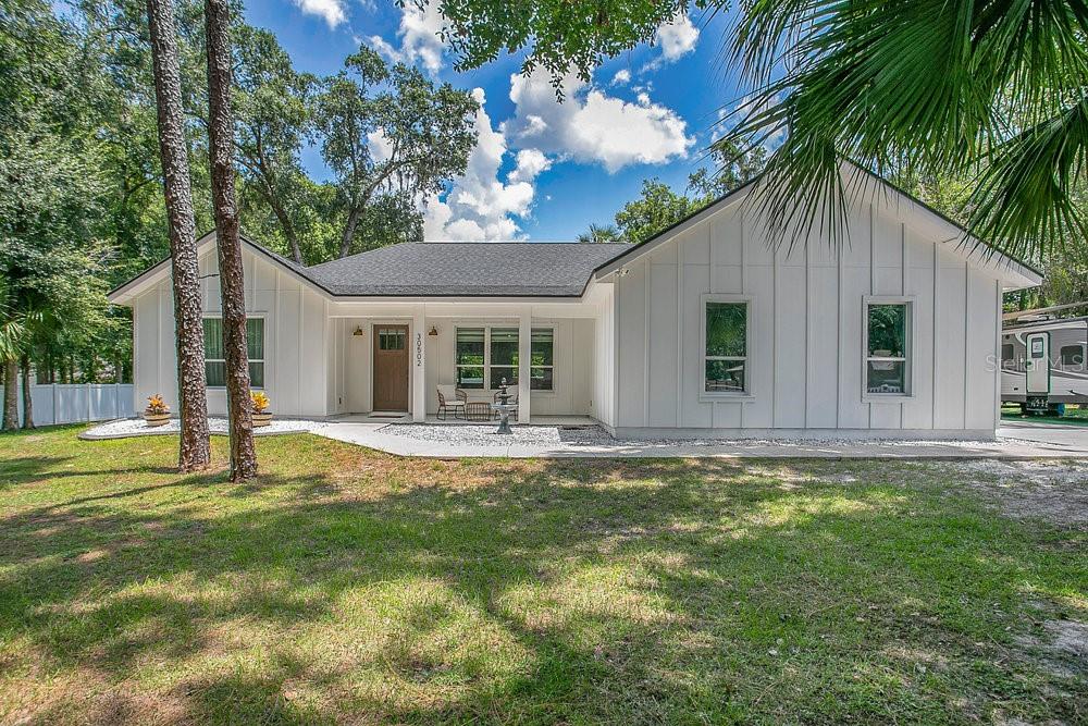 **This property QUALIFIES FOR A CREDIT UP TO $9975 through the seller's preferred lender**Welcome to this beautifully designed 4-bedroom, 2.5-bath home nestled on an OVERSIZED, FULLY FENCED LOT in peaceful Mt. Plymouth. Built in 2021 and meticulously maintained, this home FEELS LIKE NEW, offering over 2,300 SQUARE FEET of thoughtfully curated living space and modern finishes throughout. Tucked away on a quiet, NEARLY HALF ACRE LOT with no rear neighbors, this property offers rare privacy and freedom—with NO HOA restrictions. The upgraded vinyl fencing surrounds the property, providing both function and security while enhancing curb appeal. Step inside to a bright and airy OPEN-CONCEPT LAYOUT featuring luxury vinyl plank flooring throughout. The heart of the home is the MODERN CHEF'S KITCHEN, showcasing high-end Thor stainless steel appliances, a gas stove, QUARTZ COUNTERTOPS, a generous center island, and a large walk-in pantry—perfect for entertaining or everyday living. The spacious Living Room provides comfort and style with a GAS FIREPLACE and sleek modern ceiling fan, while the dining area features sliding glass doors that open to a covered rear porch, offering the perfect shady spot to relax under the overhead ceiling fan. Just beyond, you'll find a brick paver patio with a brick fire pit and an EXPANSIVE BACKYARD ready for fun, gardening, or simply enjoying the natural setting. The Primary Suite is a TRUE RETREAT, providing serene backyard views through large windows, stylish BUILT-IN SHELVING, and a walk-in closet with a CUSTOM STORAGE SYSTEM. The en suite bath is spa-like with dual sinks, a free-standing soaking tub, a walk-in shower, and a private water closet. The additional bedrooms with luxury vinyl plank flooring and BARN DOOR closets, present flexible space for family, guests, or a home office. The well-equipped Laundry Room includes a stylish contemporary sink, upper cabinets, a large storage closet and a FOLDING STATION for everyday convenience. Surrounded by lakes, parks and trails, NEARBY OUTDOOR ATTRACTIONS include Wekiva Springs State Park and Rock Springs Run, perfect for those who love to explore. Conveniently located near SR 46, SR 429, and US-441, you’ll enjoy easy access to DOWNTOWN MOUNT DORA, Lake Mary, Sanford, and Orlando. If you’re looking for a NEWER HOME with modern style, space to breathe, and NO HOA—this MT. PLYMOUTH GEM is a must-see. Schedule your private showing today!