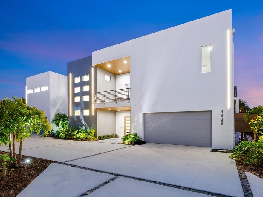 Set on the north end of Siesta Key, this striking modernist residence offers the rare balance of island serenity and seamless access to the mainland, placing vibrant downtown Sarasota, Southside Village, and the area’s cultural and dining destinations just minutes away—while the azure waters of the Gulf and Siesta Key’s world-famous white quartz sand beach are equally close at hand.
Designed with crisp architectural lines and a light-filled, contemporary aesthetic, this nearly 3,800-square-foot, four-bedroom, four-bath home redefines modern coastal living. Expansive walls of glass and open interiors create a natural flow throughout the home, blurring the line between indoors and out and capturing the relaxed elegance of island life.
Elevated and thoughtfully constructed in accordance with current building guidelines, this residence offers peace of mind without compromising style. One of the home’s most distinctive features is the private balcony hot tub, perfectly positioned for effortless enjoyment—ideal for morning relaxation or evening unwinding after a day at the beach. The property also offers ample room to add a pool, providing future flexibility to further customize the outdoor experience.
Inside, the open-concept living space is anchored by a sleek chef’s kitchen with premium appliances, a natural gas cooktop, modern cabinetry, and generous prep and gathering space—designed for both entertaining and everyday living. The primary suite is a tranquil retreat, featuring a spa-inspired bath, walk-in closet, and direct access to outdoor living. Three guest suites are thoughtfully designed to offer comfort, privacy, and flexibility.
Beneath the home, a substantial garage provides space to accommodate up to eight vehicles, along with room for additional storage—an exceptional and rarely found amenity on Siesta Key. Complementing this level is a separate flex room with an overhead door that opens directly to the backyard, making it ideal for a private home gym, wellness studio, hobby space, or additional entertaining area.
Just a short stroll away, a charming neighborhood beach at Big Pass offers a front-row seat to boats gliding through the pass and colorful sunsets each evening—a favorite local spot that perfectly captures the laid-back beauty and maritime energy of the north end of Siesta Key.
This is a compelling opportunity for buyers seeking a move-in-ready modernist home on Siesta Key’s coveted north end—where convenience, coastal beauty, and architectural sophistication come together, and where the beach, boating, dining, and Sarasota’s vibrant cultural and entertainment scene are all within easy reach.
A refined blend of modern design, prime location, privacy, and future potential, this residence delivers an exceptional Siesta Key lifestyle.
