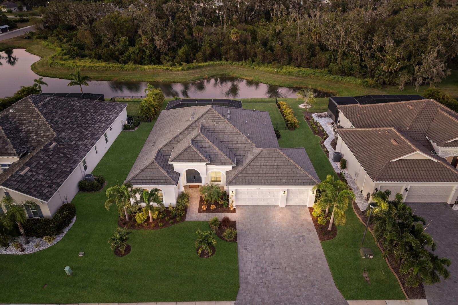 Sophisticated. Serene. Smartly designed. Welcome to the EXTENDED Aruba by Medallion Home, an exquisitely designed 2023-built residence featuring IMPACT-RESISTANT WINDOWS and SLIDERS, crafted for those who appreciate both elegance and peace of mind. This 3-bedroom, 3-bath home WITH a den/office offers a stunning open-concept layout, blending modern design with functional living and no carpet. The heart of the home — a spacious great room — flows seamlessly into the gourmet kitchen, where stainless steel appliances, quartz countertops, solid wood Kraftmaid cabinets, and an oversized island with seating invite both culinary creativity and conversation. Enjoy your morning coffee while watching for the local deer in the bright breakfast nook, highlighted by an aquarium window that bathes the space in natural light. The owner’s suite is a private retreat occupying one full wing of the home, featuring a 14' x 15' den, dual walk-in closets, and a spa-inspired ensuite with an oversized walk-in shower, dual vanities, and a private water closet. From the owner's suite you can step through French door to your private pool and spa, overlooking a tranquil pond AND preserve — a forever view, with no homes ever to be built behind you. The extended covered lanai, pre-plumbed and wired for an outdoor kitchen, is perfect for alfresco dining and entertaining. Situated on an 85-foot-wide homesite, this property offers space, privacy, and a true sense of sanctuary. Beyond beauty, this home delivers performance and peace of mind: impact-resistant windows and sliders provide storm protection, energy efficiency, and lower insurance costs — all while reducing outside noise. This home has had over $50,000 in after-closing-upgrades including a water softener & filtration system, a Clear-View pool cage, partial fenced yard, elegant lighting/ceiling fans throughout, window plantation shutters, custom wall details, custom closets/pantry, and more. Residents of this gated community of The Reserve at Twin Rivers enjoy low HOA fees with no CDD fees, covering front gate access, internet, basic cable, irrigation water, private road maintenance, and community preserve care. Perfectly located for convenience and lifestyle with 3 Publix Super Markets within 10 minutes, UTC shopping/dining center and Ellenton Outlets within 15 minutes, I-75 and I-275 access within 15 minutes, 3 international airports within less than an hour, Major League sports (Rays, Bucs, Lightning), and a new Parrish Hospital only 15 minutes away. Don’t miss your chance to experience the best of Florida living — where modern luxury meets natural tranquility.