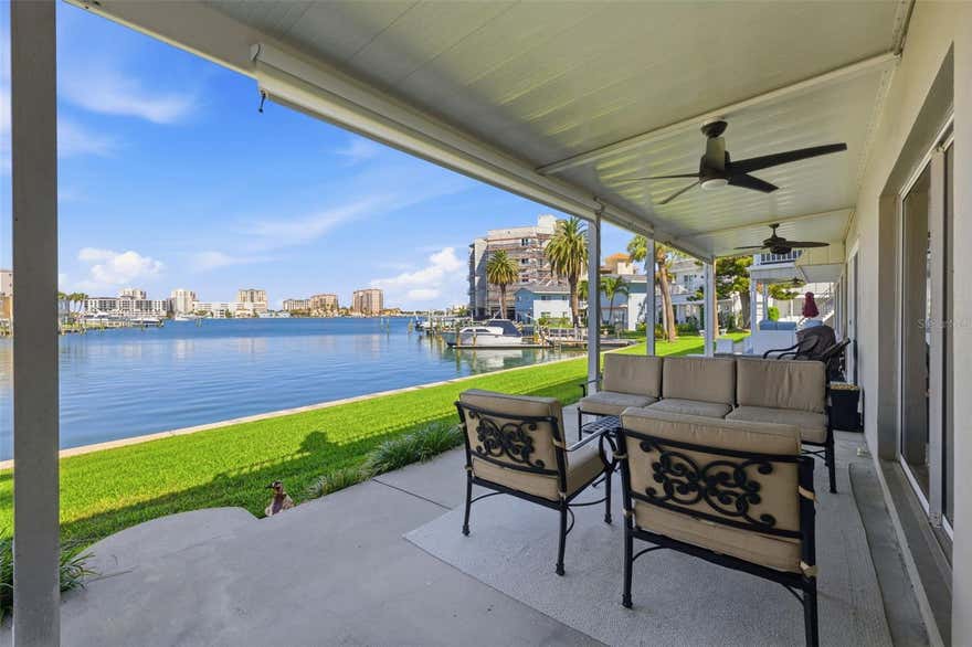 Enjoy beautiful water views from this first floor, 2 BR/2B condo in one of Island Estate’s waterfront condominiums. This renovated condo has an open design with natural lighting and a relaxed coastal vibe. The updated kitchen has a large granite island for seating and glass slider doors so you can take your dining outside to the extra wide patio overlooking the intracoastal waterway. The spacious living room also opens up to the waterfront patio so you can enjoy the waterfront breeze. Chances are good that you will see dolphins and manatees while enjoying the views! Both bedrooms have updated impact windows with plantation shutters. The primary suite has double doors and a full wall of closet space. Bathrooms have custom glass showers and a jetted tub in the primary bath. This unit has inside laundry, a Bosch dishwasher, new beautiful flooring, fresh paint throughout, granite countertops, one covered assigned parking spot, and additional guest parking. Brand new disposal, water heater and solar shade on the porch.  Island Estates is a self-contained waterfront community with several resident conveniences. This condo is centrally located and just steps from Publix, multiple restaurants, the Clearwater Marine Aquarium, UPS, a nail salon, cleaners, and a gas station. The powdered sugar sands of Clearwater Beach are also a short walk or bike ride away, or jump on the Jolly Trolley! This condo makes a great place to call home, or a second home coastal retreat.  Brand new complete AC system is on the way too!!