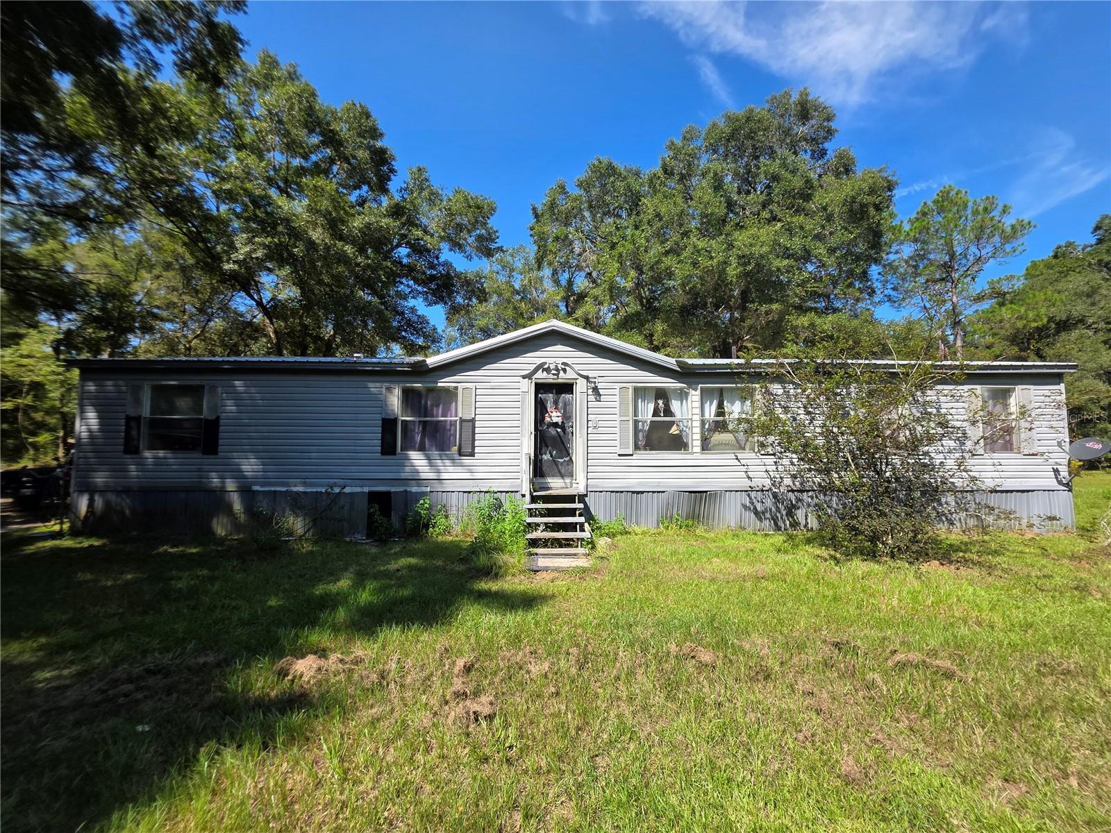 10 full acres in south Newberry. Metal roof and AC are less than three years old. About an acre is cleared where home sits so you can enjoy the wooded setting or clear more land. Near enough to the city but far enough to feel like country. Abundant wildlife right outside your window. Only 1/2 mile off paved road.
