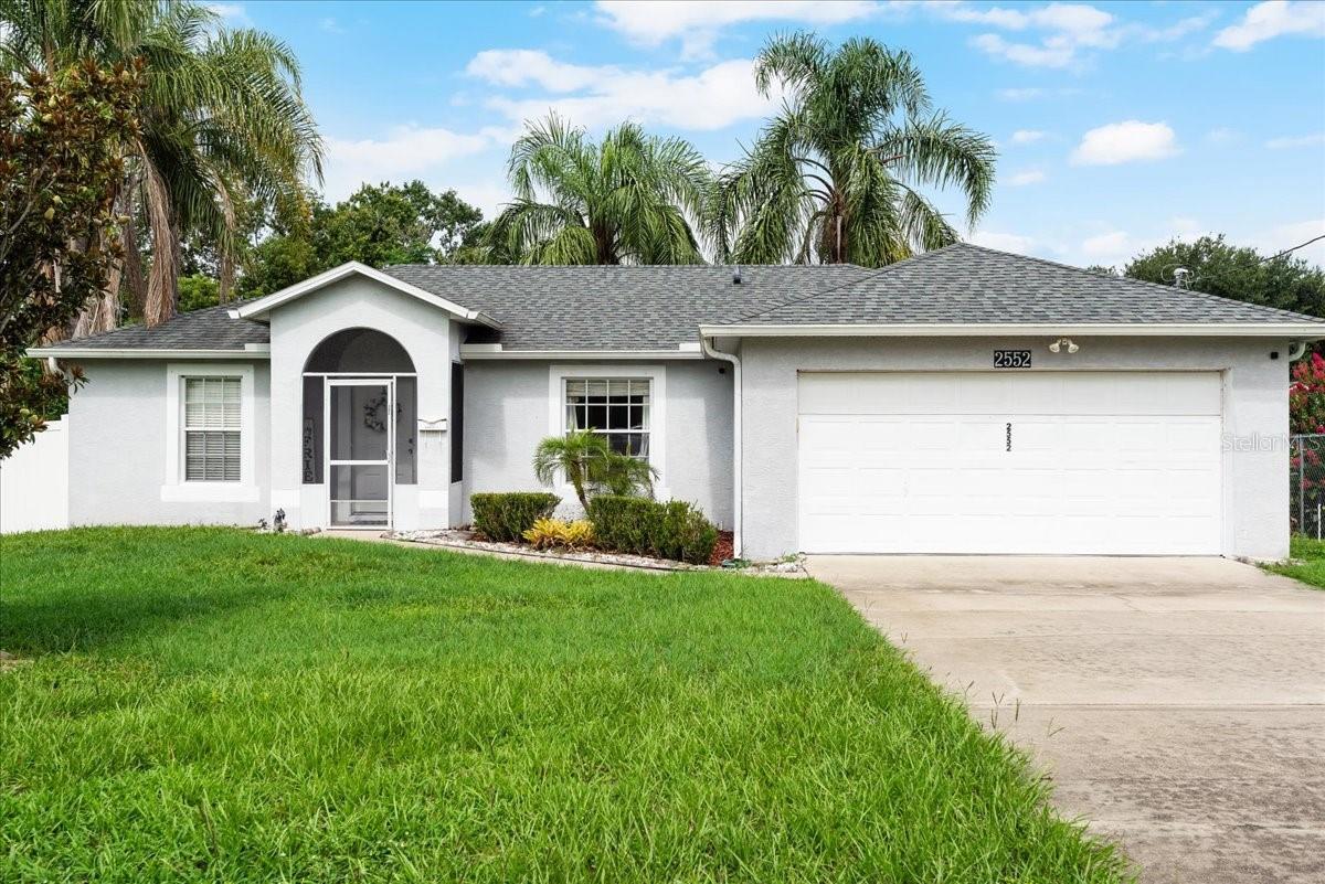 Welcome to this well-maintained and thoughtfully designed 3-bedroom, 2-bathroom home offering both style and function in a prime location with no HOA. The split floorplan ensures privacy, while vaulted ceilings in the main living spaces create an airy, open feel. Throughout the home, you’ll find laminate flooring for a cohesive, modern look, with tile in the bathrooms for easy upkeep. The kitchen is perfect for everyday living and entertaining, featuring plentiful countertop space, stainless steel appliances, a closet pantry, and a breakfast bar that opens to the dining area. Sliding glass doors from the dining space lead to a large, screened-in patio, creating effortless indoor/outdoor living and overlooking a fully fenced backyard—ideal for pets, play, or relaxing in privacy. The master suite is on the right side of the home and offers backyard views, a walk-in closet, and en-suite bathroom that has been beautifully updated, adding a fresh and contemporary touch. Two secondary bedrooms, located on the left side of the home, share an updated bathroom with single-sink vanity and shower/tub combo. With a new roof in 2020 and AC replaced in 2018, this home offers peace of mind and energy efficiency. Located just minutes from shopping, dining, and everyday conveniences, it’s the perfect place to call home.