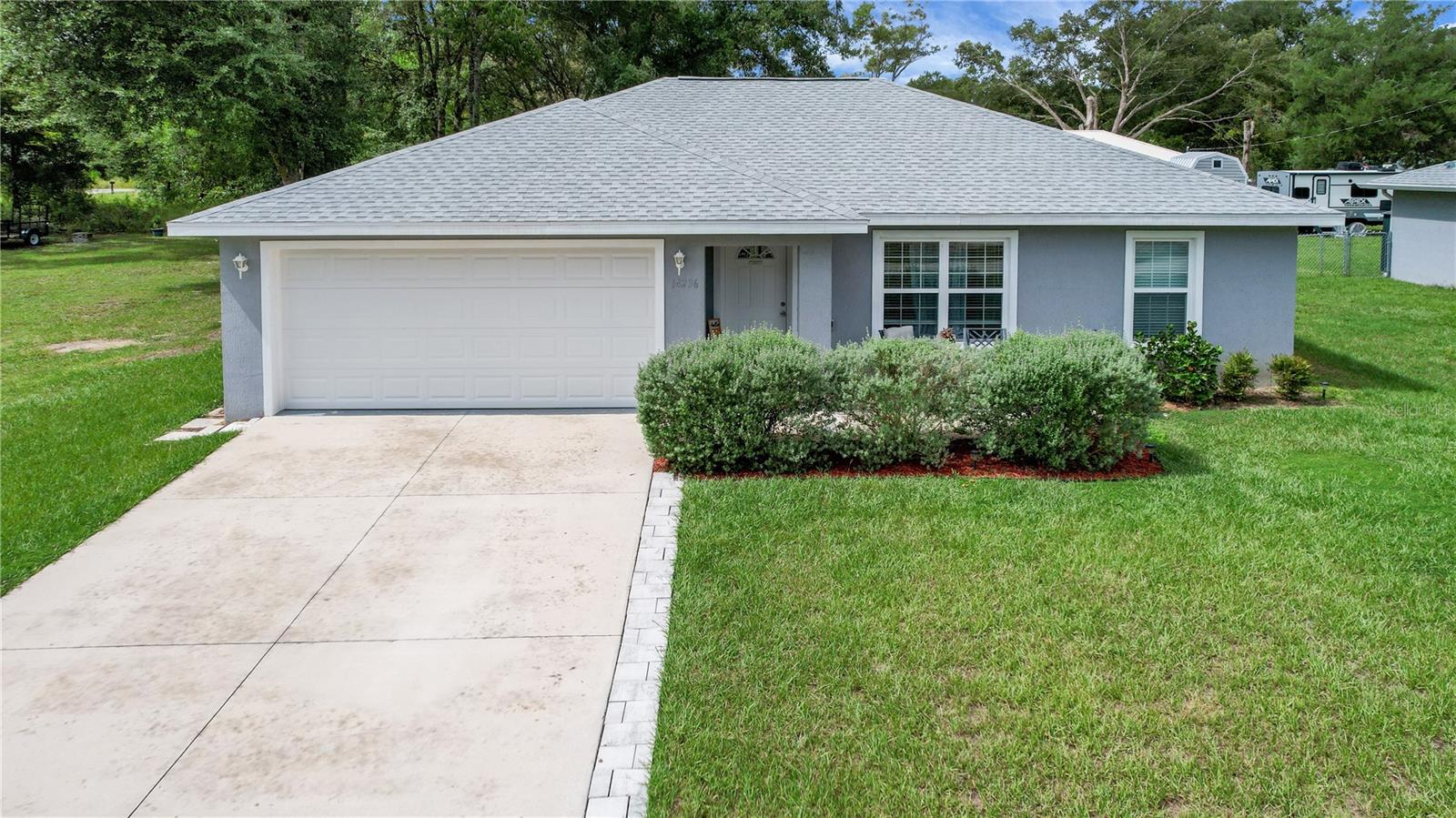 Welcome to this beautiful 3-bedroom, 2-bathroom home with 2 car garage located in desirable Belleview Heights Estates! Built in 2022, this modern home offers 1,278 square feet of thoughtfully designed living space. Step inside to find luxury vinyl plank flooring throughout — no carpet — soaring ceilings, and an open floor plan that creates a bright, inviting atmosphere. The stylish kitchen boasts gray cabinetry, granite countertops, stainless steel appliances, and a convenient breakfast bar — perfect for casual dining or entertaining guests. The spacious primary suite includes a walk-in closet and a private en suite bathroom featuring a sleek, tiled walk-in shower, gray cabinetry, and granite countertops. The guest bathroom offers matching granite and a tub/shower combo with elegant tilework. Enjoy outdoor living on the covered lanai overlooking the large backyard — ideal for relaxing or hosting gatherings. Conveniently located in Summerfield near Hwy 42, you're less than 20 minutes from The Villages, with shopping, dining, and medical services just 10-15 minutes away.