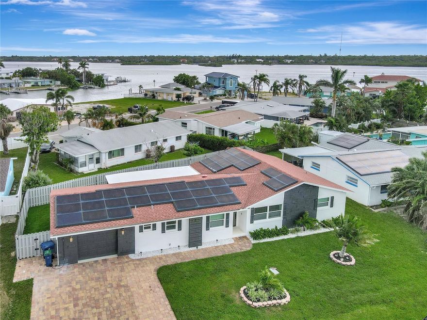 Gulf Coast Living at its Best – Fully Remodeled! This beautifully renovated 3-bedroom, 2-bathroom home in this sought after neighborhood of Redington Shores offers the perfect blend of coastal charm, modern design, and sustainability — just a short walk to the pristine white sands of the Gulf of Mexico. Following an extensive remodel, every detail is fresh and move-in ready. The open, split-bedroom floor plan features a stunning new kitchen with all-wood cabinets, granite countertops, stainless steel appliances, and a spacious center island — ideal for entertaining. Both bathrooms have been tastefully redesigned, and the home boasts wood-look porcelain tile throughout for a clean, cohesive feel. Energy efficiency shines with Tesla solar panels, PGT impact windows and doors, and separate AC for the master suite and office. Additional upgrades include new HVAC systems, new washer/dryer, and artificial turf in the backyard for zero-maintenance landscaping. Enjoy the generous screened patio and private turf backyard, perfect for outdoor living, plus a large paver driveway with room for a boat and quick access to the public boat ramp. Furnishings are negotiable, making it easy to start enjoying your new beach lifestyle right away.
