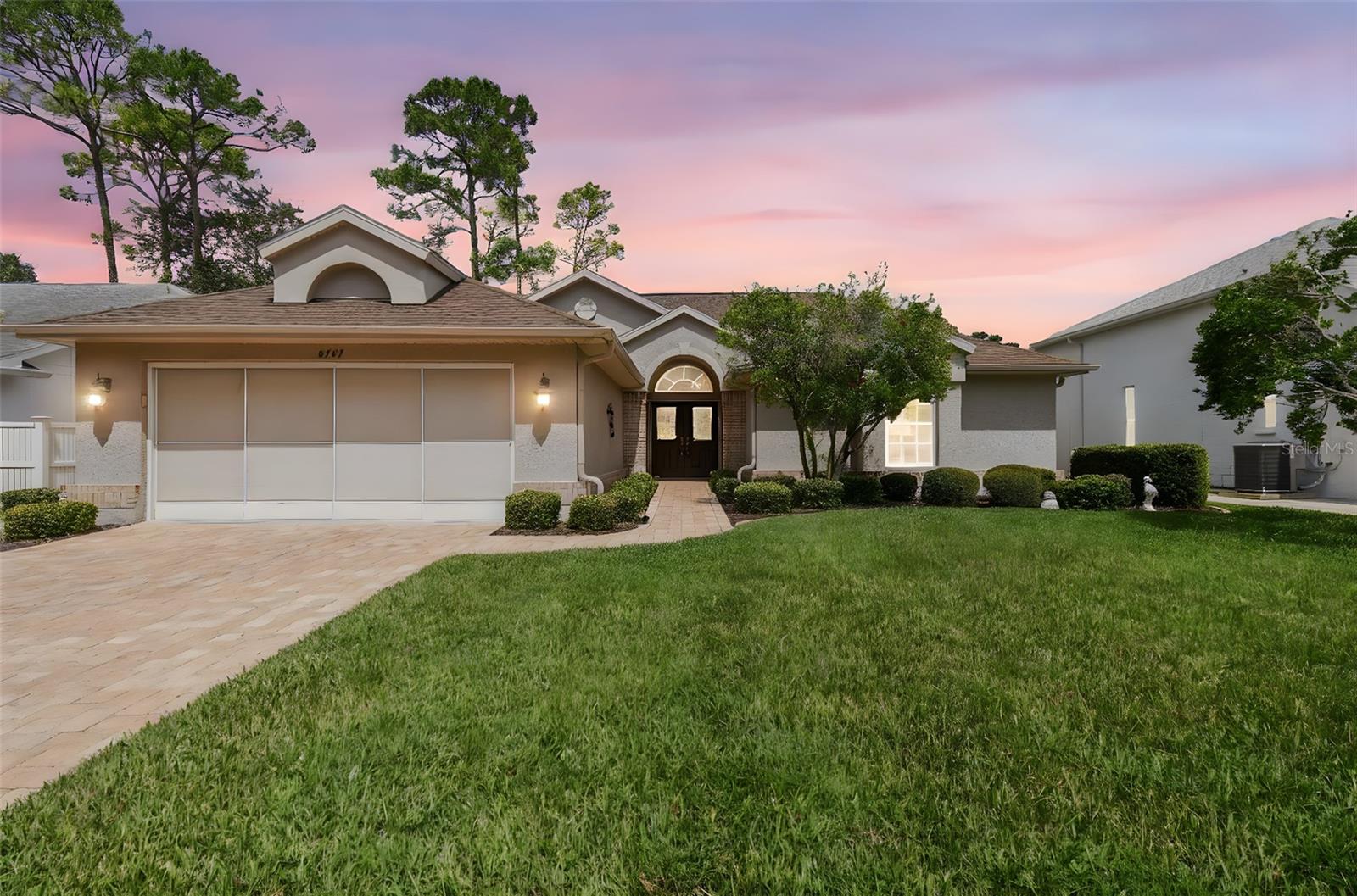 One or more photo(s) has been virtually staged. Enjoy scenic golf course views and relaxed Florida living in this spacious 3 bedroom, 2 bath home located in Timber Pines, a gated 55+ community known for its resort-style amenities. The oversized 2 car garage includes a separate golf cart entrance, and the dual-door tiled foyer welcomes you into an open, airy layout. The vaulted-ceiling great room features a dual-sided gas fireplace with brick surround, flowing into a tiled eat-in kitchen with breakfast bar, dual sinks, solar tube lighting, two pantries, and a cozy dining nook. A formal dining room adds space for entertaining. The expansive primary suite offers vaulted ceilings, dual sinks, jetted tub, separate shower, linen closet, and two walk-in closets including a wraparound design. Bedrooms two and three also include walk-in closets, with one featuring French doors. Relax year-round in the enclosed lanai with heat and air, overlooking the manicured fairways. Additional upgrades include a screened garage, 2018 roof, 2023 HVAC system, brick paver driveway and walkway, gutters, transom windows, paneled interior doors, plant shelves, ceiling fans, pristine landscaping, interior laundry room with wash tub and cabinetry, two pocket sliders to the lanai, attic access with pull-down stairs, and irrigation system. Open floor plan concept promotes effortless living throughout. HOA includes Spectrum cable and high-speed internet. Timber Pines offers four golf courses, a country club, renovated restaurant and bar with multiple TVs, two pools, fitness center, tennis and pickleball courts, bocce ball, billiards room, and over 100 active clubs. Whether you're teeing off at sunrise or winding down with neighbors at sunset, this home delivers the best of Florida’s golf lifestyle. Schedule your private showing today!