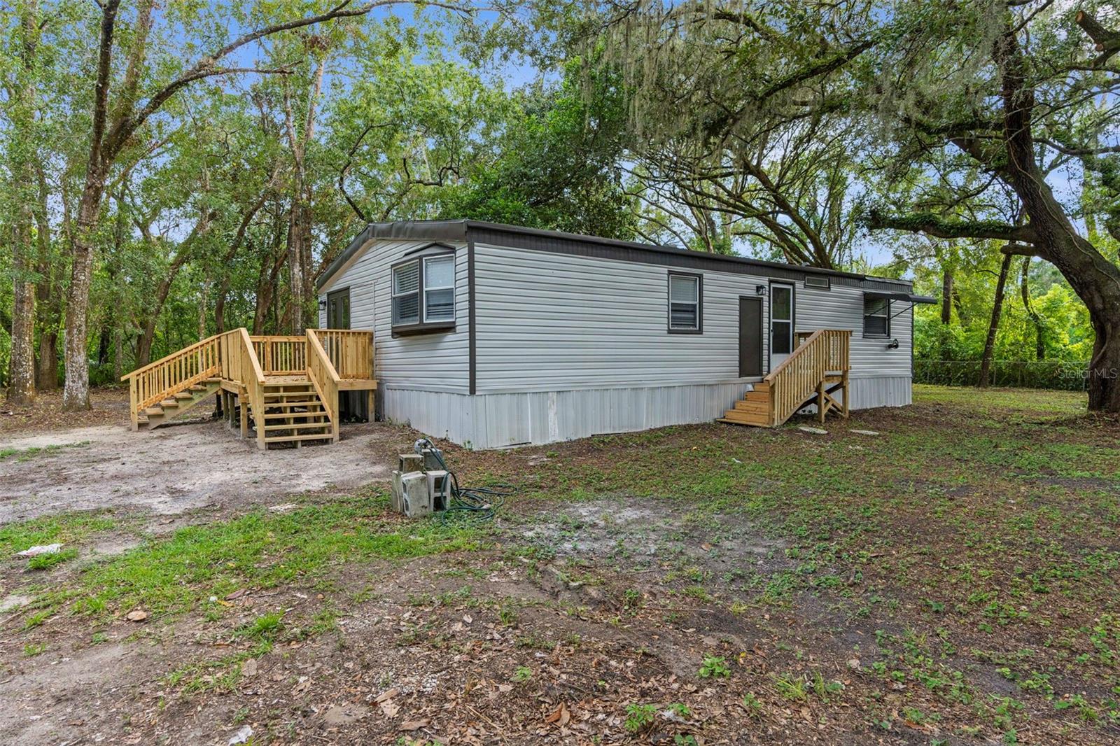 MOVE-IN READY!! SUPER NICE and CLEAN!! REMODELED!! 3/2 double wide nestled in the trees on a DOUBLE lot (half acre) and completely fenced and gated!! Located near the Suncoast Parkway and County Line Road for quick and easy access to everything!! 3 bedrooms + 2 full bathrooms + inside laundry room + deck (20x11) + metal roof in 2009 + AC 2020 + truly nestled in the gorgeous canopy of large live oak tress for complete privacy and completely fenced and gated for security! Lots of yard space for the family and pets!!
REMODELED Kitchen with new white shaker cabinets, countertops, and stainless steel appliances! All new luxury vinyl plank flooring! Newly painted inside...so it's nice and clean! Large master bedroom with ensuite bathroom and walk-in closet. Also, one of the additional bedrooms is extra large with a walk-in closet, as well.
1,188 sq feet living space! Zoned R1A. NO FLOOD!! NO HOA!! So bring your camper, RV, boat, ATVs...lots of place to park - add a carport or detached garage to make it your own! The double lot is nice and square (144' x 150')!
No neighbors right on top of you and the home feels very private and secluded even though you are so close to everything...shopping, restaurants, the parkway to Tampa, Anderson Snow Water Park, soccer, baseball, and softball fields!
Home is a 1980 and was moved there in 2020. If you are not a cash buyer, ensure you are using a lender that will finance on a manufactured home that was relocated. If you don't have one...ask! Move right in! Come see it today!!
