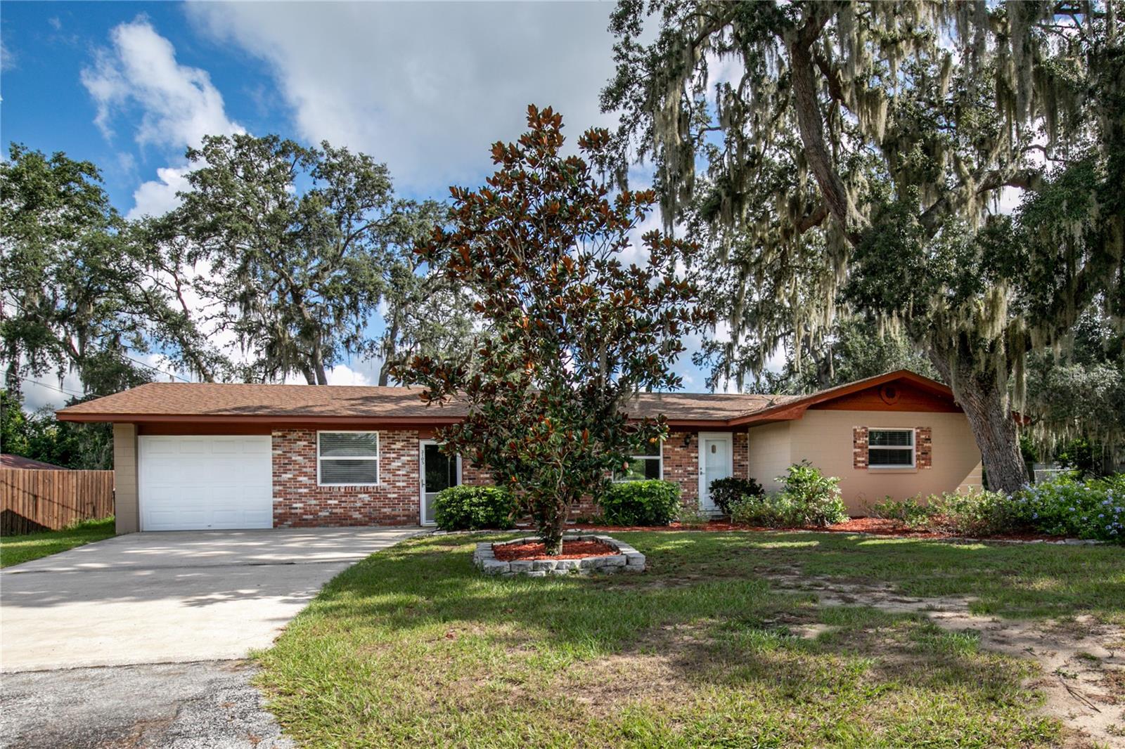 Welcome to this well-maintained 3-bedroom, 1.5-bath home in a mature Eustis neighborhood shaded by beautiful oak trees. Situated on a generous lot, the property features a 1-car garage, a spacious 20x24 detached carport, and a chain-link fenced backyard—perfect for enjoying the outdoors or accommodating pets and hobbies. Inside, you'll find a bright and tidy interior with an enclosed Florida room, a large utility/laundry room conveniently located off the garage, and a practical floor plan. The primary bedroom includes a half-bath ensuite, offering a little extra privacy and comfort. Mature landscaping adds charm and curb appeal, and a separate irrigation well helps keep everything green and thriving year-round. As a resident of this neighborhood, you'll have the option to join a community with access to Lake Joanna—a spring-fed lake known for boating and fishing. The optional fee includes access to a private park, playground, dock, and designated swimming area.
Living in Eustis, Florida offers the best of both worlds: small-town charm with big-time convenience. Located in the heart of Lake County, you're just minutes from shopping, dining, and local festivals. Plus, with easy access to major highways, Orlando, theme parks, and Florida's beautiful beaches are all within reach for day trips or weekend getaways.