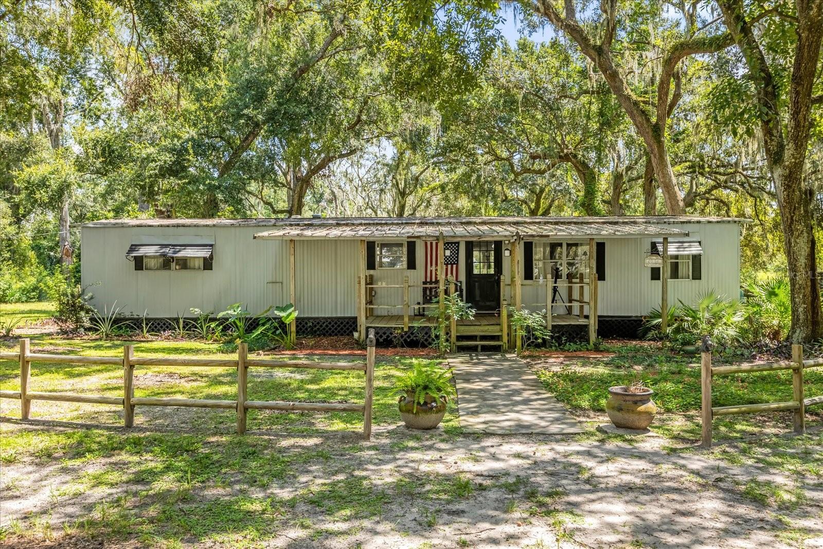 10 ACRES - ZONED AGRICULTURAL - NO HOA - NO CDD - 6 ACRES HIGH AND DRY - HORSE STABLES, OUTBUILDING/WORKSHOP, AND MULTIPLE FENCED AREAS - EFFECTIVE DATE 1990 - OPEN CONCEPT DESIGN - INDOOR LAUNDRY - FRONT AND REAR PORCHES - FENCED BACKYARD
Escape the ordinary and embrace country living on this stunning 10-ACRE AGRICULTURAL PROPERTY with NO HOA and NO CDD! Tucked away among beautiful trees and open clearings, this property is a dream come true for those who love wide-open spaces, fresh air, and the freedom to create their ideal lifestyle. With approximately 6 ACRES HIGH AND DRY the land offers the perfect balance of cleared pastures and wooded privacy. Once used to board horses, the property is already equipped with HORSE STABLES, OUTBUILDING/WORKSHOP, AND MULTIPLE FENCED AREAS ready for animals, livestock, or gardening. Whether you envision raising horses, goats, chickens, or simply enjoying the peaceful beauty of nature, the possibilities here are endless.
The charming manufactured home (EFFECTIVE DATE 1990) is warm and inviting, featuring an OPEN CONCEPT DESIGN with a spacious living room, breakfast bar kitchen, and a large formal dining room perfect for family gatherings. The primary bedroom offers a private ensuite, while a separate guest bath and INDOOR LAUNDRY make everyday living convenient. Relax on the FRONT AND REAR PORCHES and take in the sights and sounds of the countryside. The FENCED BACKYARD provides a safe retreat for pets or play.
This is more than a property—it’s a lifestyle. Whether you’re dreaming of a working farm, a peaceful homestead, or a private getaway surrounded by nature, this property is ready for you to enjoy today and improve for tomorrow.