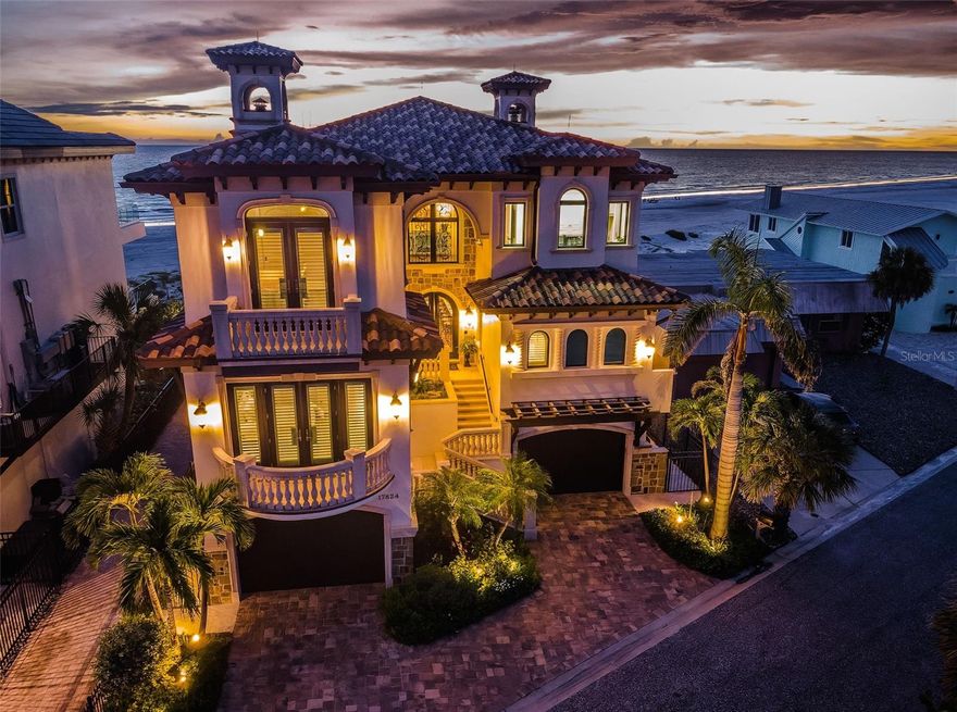 What happens when Tampa Bay’s premier architect, most accomplished structural engineer, and most respected builder come together? The result is an extraordinary beachfront residence that merges architectural brilliance, meticulous engineering, and beautiful state-of-the-art construction. Dan Dawson, Koly International, and Monogram Builders have created a modern 7719 sqft under one roof Gulf-front masterpiece where every detail has been carefully considered, tested, and refined. Balanced and cantilevered concrete engineering minimize columns and maximize sweeping Gulf views. Built on a foundation of 47 pilings, poured concrete structural columns, and poured concrete floors on every level, the home offers superior strength that is unmatched in the Tampa Bay area. Hurricane-rated windows and doors, and a roofing system engineered for the harshest coastal conditions help create a residence that is designed to last for generations. The impressive structural integrity is matched by luxurious, finely crafted finishes. Cast stone accents and custom exterior detailing set the tone, leading into a grand covered entry. Inside, you’ll find an open floor plan designed for Gulf front living, with porcelain floors that echo the look of distressed Brazilian hardwood, level 5 drywall, intricate woodwork, designer lighting, custom ceilings, and integrated whole-house audio, lighting, and electronics. The gourmet kitchen is a chef’s dream – boasting expansive granite counters, custom cabinetry, double islands, two bar seating areas, Wolf / Subzero appliances, dual Miele luxury dishwashers, gas cooking, and a hidden pantry with built-in work center. The adjoining dining space opens to a covered beachfront balcony, while the Gulf-front living room offers coffered ceilings, a gas fireplace, and wide balcony access. A unique 3-stop glass elevator with custom hammered copper finish adds artistry to function. The beachfront owner’s suite is an indulging retreat, with luxe ceilings, a private balcony and a custom mahogany closet system. The spa-like bath contains a hammered copper soaking tub, dual vanities, cosmetics station, and a glass-enclosed rain shower. The four additional bedroom suites include two with Gulf-front balconies and two bedrooms with their own private terrace overlooking the Intracoastal Waterway. Step out back and discover a true beachfront oasis: a zero-entry PebbleTec pool and spa with cascading stone waterfall, expansive Travertine paver deck, 800 sq ft of covered outdoor living space with a built-in gas cooking center and bar, a stone-encased gas fireplace, and separates area for dining and entertaining. With additional features including a 22KW Generac gas generator, dual Rinnai tankless water heaters, central vacuum system, and countless luxury details, this home delivers an uncommon luxury Gulf front living experience built with unparalleled precision, quality and elegance. Dimensions are estimates, buyer to verify.