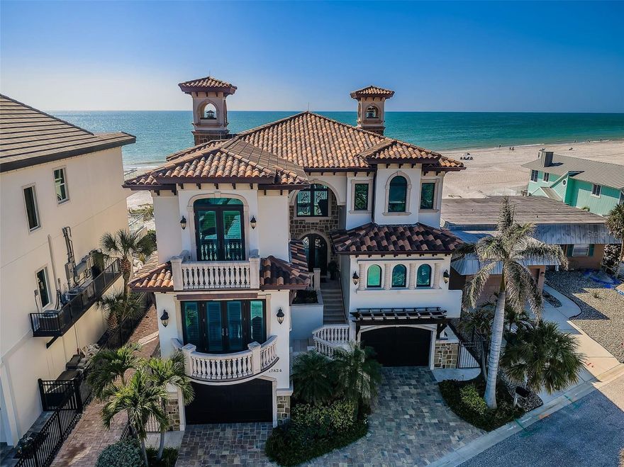 What happens when Tampa Bay’s premier architect, most accomplished structural engineer, and most respected builder come together? The result is an extraordinary beachfront residence that merges architectural brilliance, meticulous engineering, and beautiful state-of-the-art construction. Dan Dawson, Koly International, and Monogram Builders have created a modern 7719 sqft under one roof Gulf-front masterpiece where every detail has been carefully considered, tested, and refined. Balanced and cantilevered concrete engineering minimize columns and maximize sweeping Gulf views. Built on a foundation of 47 pilings, poured concrete structural columns, and poured concrete floors on every level, the home offers superior strength that is unmatched in the Tampa Bay area. Hurricane-rated windows and doors, and a roofing system engineered for the harshest coastal conditions help create a residence that is designed to last for generations. The impressive structural integrity is matched by luxurious, finely crafted finishes. Cast stone accents and custom exterior detailing set the tone, leading into a grand covered entry. Inside, you’ll find an open floor plan designed for Gulf front living, with porcelain floors that echo the look of distressed Brazilian hardwood, level 5 drywall, intricate woodwork, designer lighting, custom ceilings, and integrated whole-house audio, lighting, and electronics. The gourmet kitchen is a chef’s dream – boasting expansive granite counters, custom cabinetry, double islands, two bar seating areas, Wolf / Subzero appliances, dual Miele luxury dishwashers, gas cooking, and a hidden pantry with built-in work center. The adjoining dining space opens to a covered beachfront balcony, while the Gulf-front living room offers coffered ceilings, a gas fireplace, and wide balcony access. A unique 3-stop glass elevator with custom hammered copper finish adds artistry to function. The beachfront owner’s suite is an indulging retreat, with luxe ceilings, a private balcony and a custom mahogany closet system. The spa-like bath contains a hammered copper soaking tub, dual vanities, cosmetics station, and a glass-enclosed rain shower. The four additional bedroom suites include two with Gulf-front balconies and two bedrooms with their own private terrace overlooking the Intracoastal Waterway. Step out back and discover a true beachfront oasis: a zero-entry PebbleTec pool and spa with cascading stone waterfall, expansive Travertine paver deck, 800 sq ft of covered outdoor living space with a built-in gas cooking center and bar, a stone-encased gas fireplace, and separates area for dining and entertaining. With additional features including a 22KW Generac gas generator, dual Rinnai tankless water heaters, central vacuum system, and countless luxury details, this home delivers an uncommon luxury Gulf front living experience built with unparalleled precision, quality and elegance. Dimensions are estimates, buyer to verify.