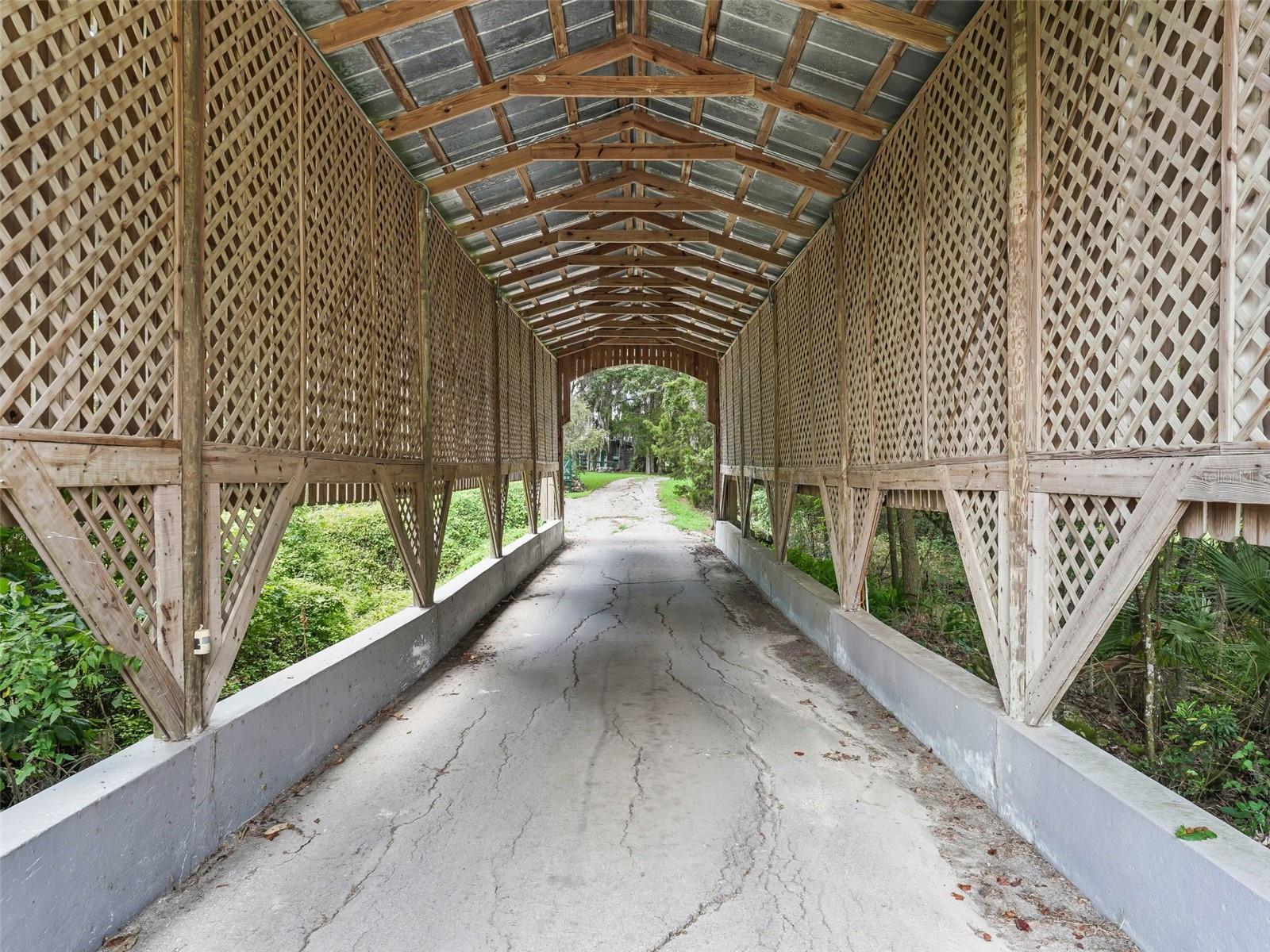 This estate sits on 5.28 acres and is one of the highest elevation points on the road. The property is conveniently located just 8 minutes from the World Equestrian Center as well as close proximity to dining and shopping options. It presents a stunning, serene environment with a three bed/two bath home and a secluded setting. A picturesque covered bridge adds a touch of charm and character to the landscape. Two wells one regular size and one large for equestrian needs are present as well as two outside sheds for additional storage. Two distinctive round pins provide unique architectural elements and suited for equestrian needs. Four barns are also on the property. The hidden nature of the property is like being in your own private park, insuring privacy and tranquility. Various types of trees surround the property, including oak, cedar, and a couple of fruit trees. The overall impression is rustic elegance and natural beauty, which would be ideal for those seeking a peaceful retreat and place to call home.