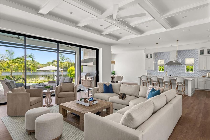 Welcome to a rare opportunity to embrace the Winter Park lakefront lifestyle in this custom-built masterpiece that blends timeless architecture with relaxed coastal sophistication. Crafted by Hanson Custom Homes and thoughtfully curated by Kate Voss Interiors, this modern coastal residence offers the perfect setting for those who value both refined living and a vibrant, connected lifestyle. With top-rated Winter Park schools, endless parks, bike paths, and the shopping, dining and events at Park Avenue and Baldwin Park just minutes away, the owners of this home spared no expense in creating a unique blend of luxury and livability in one of Central Florida’s most desirable communities.  Step inside to soaring 14-foot ceilings, custom millwork, and a 20-foot Euro glass wall that disappears into a hidden pocket—blurring the line between indoors and out and filling the home with lake breezes and natural light. Whether you're hosting birthday parties by the lake, poolside barbecues, or just soaking in the serenity of a morning coffee on the water, this home was built to bring people together. The open-concept kitchen features exotic quartzite counters, a touchless faucet, Thermador appliances, and a full butler’s pantry and flows seamlessly into an expansive outdoor living space with motorized screens, a full summer kitchen, and views that stretch across your private beach and dock. Just steps from the pool, the lake becomes your playground—ideal for paddleboarding, fishing, or sunset cruises on your boat or jet ski. The primary suite comes complete with water views, motorized drapery, and spa-worthy bath finishes—including a steam shower, soaking tub, and private porch access. The main living areas are built for both entertaining guests and cozy family nights in, while the resort-style pool and spa deliver year-round fun with dual heat sources, LED lighting, and coral stone decking. Upstairs, every bedroom features lake views, walk-in closets, and smart layouts that offer both privacy and togetherness. The bright, central loft is perfect as a media room, homework space, or game lounge, keeping the family connected without sacrificing space. Energy-efficient spray foam insulation, an EV-ready oversized 3-car garage, smart-home integration, impact-rated glass, and commercial-grade soundproofing are just a few of the features that make everyday living seamless and secure. This one-of-a-kind property is ideally positioned with easy access to both Winter Park’s iconic charm and Baldwin Park’s family-friendly amenities—a true gem that offers the rare combination of newer construction, world-class craftsmanship, and a lifestyle built for generations to enjoy. There’s simply nothing else like this on the market. If you’ve been waiting for a newly built custom lakefront home that combines relaxed luxury with the best of Winter Park family living—this is the one. Call today to schedule your private showing.