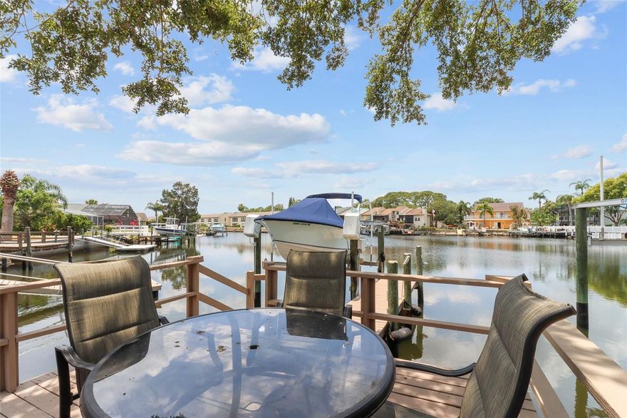 BIG PRICE IMPROVEMENT! WATERFRONT! GOLF CART FRIENDLY all the way to downtown New Port Richey!! BEST VALUE ON THE WATER from GULF HARBORS, GULF HARBORS WOODLANDS to FLOR A MAR. Keep your boat on the 10,000LB BOAT LIFT in your backyard.   Cruise to the GULF OF MEXICO from the DEEP WATER COVE with NO FIXED BRIDGES. Gulf Harbors PRIVATE BEACH and YACHT CLUB are both available for an additional fee. The best part is that all this comes with a house!  

The open floor plan boasts updates throughout, including NEW PEX PLUMBING PIPES with a 25 YEAR WARRANTY.  The bright, modern kitchen with granite countertops flows to an eating nook that overlooks the cove. Spend time unwinding with the tranquil Koi Pond and fountain. Retreat to the master suite, which includes two walk-in closets, double sinks,  and views of the water! The second bedroom offers a spacious sanctuary. The third room is a 10x12 BONUS ROOM spacious enough to be what you need; bedroom, office, or whatever works for you! The NEWER HW HEATER (2022), AC (2021) and ROOF (2015) will give you peace of mind. The community features a clubhouse, pool, tennis courts and private boat ramp.