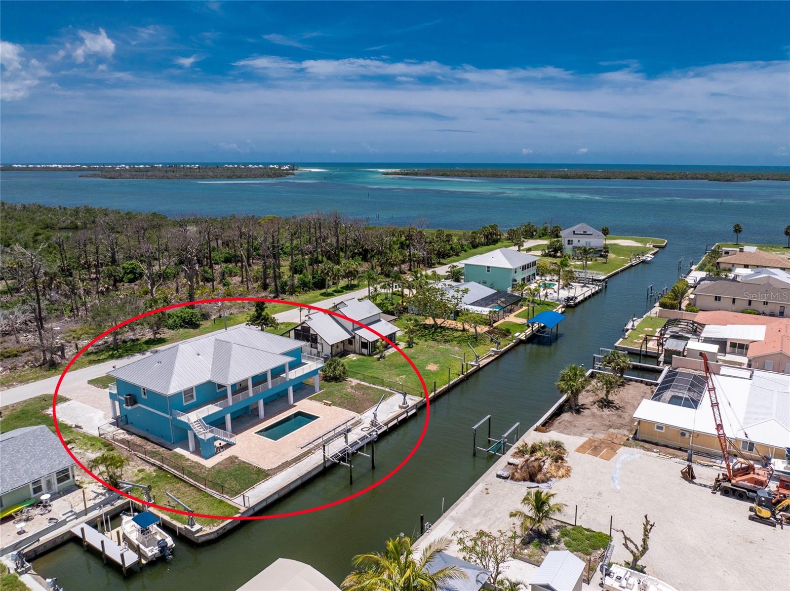 This WATERFRONT - NO BRIDGES TO BAY - HOME IS BUILT LIKE A FORTRESS! Concrete block stucco construction all the way up, with poured slab concrete flooring, and a METAL roof! Impact doors and windows! Finished floor elevation is over 18 feet, so flood insurance will be very affordable. Don't worry about all the steps as there is an elevator. With 100' ft of seawall and a covered 7000# boat lift, you can walk right out of your home, jump in the boat, and be in Lemon Bay in minutes, with fast access to Stump Pass and the Gulf of America! Very open great room design floor plan allows furniture placement in all kinds of different configurations! The kitchen features maple cabinetry, and solid surface countertops, and pantry for extra storage. Stainless appliance package includes: smooth top stove, dishwasher, built in microwave, and French door refrigerator. (all Kenmore) Laundry room is handily located just off the kitchen, and includes Kenmore front load washer and dryer. The primary bedroom has a walk in closet, ceiling fan, and ensuite bath, with double vanities w/solid surface countertops and a step in shower with easy clean solid surface walls. Guest bedrooms both have ceiling fans and walk in closets, and share a Jack and Jill bathroom, which features a combo tub/shower w/solid surface walls, linen closet, and vanity w/double basins. Each bedroom has it's OWN AC CONTROL PANEL AND ZONE! Half bath is conveniently located just off the Great room. The existing stained concrete flooring provides an opportunity to install whatever kind of flooring you like. Home is equipped with both central vacuum and a security system. Water heater was new in 2024, and AC system in 2020. Huge garage has all the storage you may need, with two automatic garage door openers. Catch some rays in your Pretty Pebbletec pool with paver decking. There's a 1300 gallon cistern that is filled from rainwater, providing an easy and inexpensive way to fill the pool or water your plants! Huge covered area downstairs would be just perfect for an outside kitchen. This home sustained NO HURRICANE DAMAGE AT ALL FROM HURRICANE IAN, and only about 27" of water in the garage from Milton. (concrete block walls made for easy cleaning!) Call today for your private appointment to see this home!