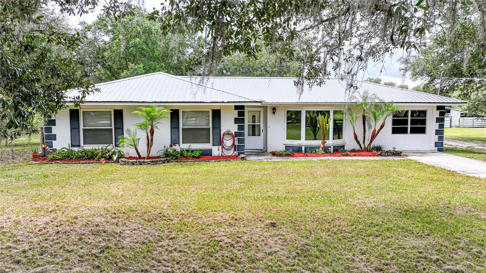 Dreaming of wide open spaces, peaceful mornings, and room to roam? This is it. Welcome to your own private slice of country heaven, sitting pretty on over 7 acres of gorgeous, fenced and cross-fenced land perfect for animals, gardens, and your wildest homesteading dreams. The concrete block home offers 3 bedrooms, 2 bathrooms, and two bonus rooms, giving you all the flexibility you need. Office? Gym? Playroom? Craft cave? You decide. Step outside and you’ll find fresh landscaping, a rear deck for golden hour views, a detached garage, and extra outbuildings ready for storage, hobbies, or turning into the ultimate chicken coop setup. And with a brand new septic system already in place, one of the big boxes is already checked. Yes, the house needs a little love: new floors, fresh paint, and a bathroom glow-up, but it’s priced perfectly for you to build instant equity while adding your own personal style. Whether you're dreaming of a mini-farm, a quiet country retreat, or just a whole lot of space to spread out, this one has the bones, the land, and the lifestyle. Come see what country living can really look like.