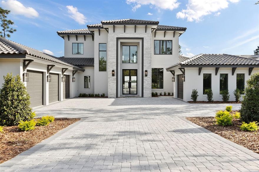 This stunning lakefront 2-story custom estate boasts 5 bedrooms, 6 bathrooms, and a split 4-car garage with southern backyard exposure and the opportunity for a private boat dock. Enter through grand double iron doors into a soaring 24' foyer with a striking glass balustrade staircase and custom wine cellar beneath. Engineered hardwood floors flow through the open-concept first floor, featuring a great room with tray ceilings and sliding doors that lead to a backyard oasis.

The great room, with tray ceilings, seamlessly transitions to the backyard through two sets of sliding glass doors, offering a perfect blend of indoor and outdoor living. The gourmet kitchen is a centerpiece, featuring wiht shaker-style and honey Carini cabinets with gold accents, a waterfall-edge island, and top-tier Fisher & Paykel appliances, including an 8-burner gas range, convection oven, and wine cooler. A spacious walk-in pantry off the kitchen ensures ample storage and organization.

The first-floor primary suite offers a serene retreat with private porch access overlooking the pool. The spa-like ensuite bath includes dual vanities, his-and-her toilets, and a freestanding tub elegantly enclosed within a walk-in shower. A custom-built walk-in closet and an additional closet provide versatile storage.

Rounding out the lower level is a thoughtfully designed office, ideal for those who work from home. A functional mudroom and laundry room add convenience, while a hidden guest suite, cleverly tucked behind a pass-through door in the kitchen, offers privacy and comfort for visitors. The expansive game room is an entertainer’s dream, featuring tray ceilings, a wet bar, and sliding glass doors lining two sides of the space. Pocket sliders open seamlessly to the outdoor entertaining area, where a travertine-tiled summer kitchen awaits.

Upstairs, three generously sized bedrooms each include ensuite baths and walk-in closets. An open loft offers a flexible space, with both the loft and one of the bedrooms providing access to a covered balcony overlooking the pool. The backyard is a true oasis, featuring a rectangular infinity-edge pool with a sun shelf and an integrated spa for year-round relaxation. This home is the perfect blend of luxury, functionality, and resort-style living.

The Club at Bella Collina provides year-round culinary experiences and social events for all ages. Play a round of golf on the Nick Faldo-designed course or unwind on one of the scenic restaurant terraces. Additional amenities include lighted Har-Tru tennis courts, pickleball courts, an outdoor pool complex, and a spa and fitness center offering a variety of complimentary fitness classes. Contact us today to discover more about this exceptional home in Bella Collina!