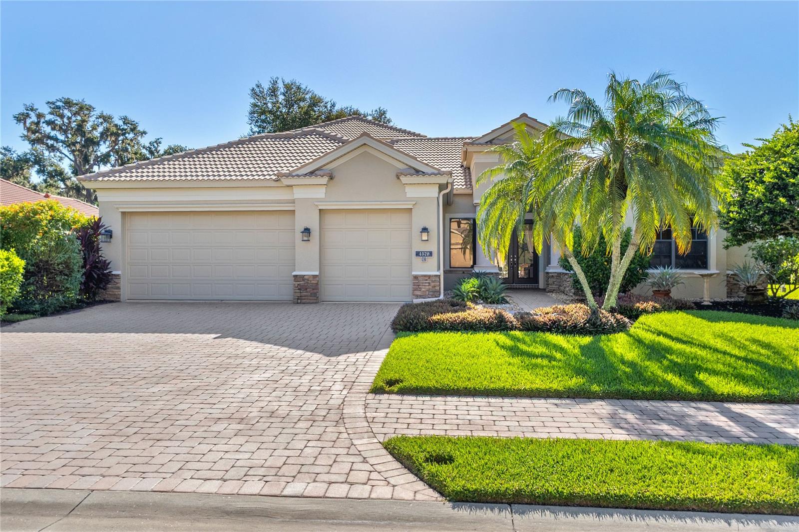 Behind the gates of Tuscana, a premier Lee Wetherington community, discover this spacious pool home, ideal for families or those who love to entertain. From the moment you enter, you will be welcomed by soaring ceilings and expansive sliders that fill the home with natural light and draw your gaze to the impressive outdoor living space. The backyard features an oversized lanai, lush landscaping, and an outdoor kitchen, perfect for indoor-outdoor living year-round. This thoughtfully designed home offers 4 bedrooms, each with its own private bathroom, plus a dedicated office and ample closet space throughout. The first-floor master suite is a true retreat, complete with two walk-in closets, bay windows overlooking the lanai, and a luxurious ensuite bath featuring a private sauna, soaking tub, and walk-in shower. Upstairs, two additional bedrooms are connected by a spacious bonus room, ideal for a media room, gym, or playroom as well as a private balcony with views of the pool. The heart of the home is a chef's kitchen with granite countertops, a natural gas stove, and island, flowing seamlessly into the breakfast nook and family room. Corner pocket sliders open the space entirely to the lanai, perfect for entertaining. A 3-car garage offers plenty of room for vehicles and storage, making this home as practical as it is beautiful. Don't miss the chance to live in this meticulously maintained community, located near the best of Sarasota's shopping, dining, beaches, and more.