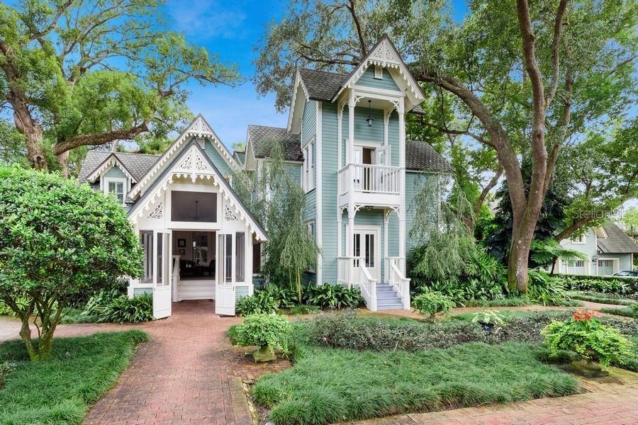 On almost one acre in the heart of Winter Park, this beautiful Victorian home was extensively and meticulously remodeled and modernized in 2002 and 2011, while still retaining its historic character and preserving many of its irreplaceable historic details. Major improvements in 2021 include new roof with attractive copper eave drip over all buildings, 3 new air conditioners, new hot water heaters and new pool equipment. This beautiful property consists of a 3 bedroom, 4.5 bath main house; detached 3 car garage with 4th private office/guest suite above; and complete 2 bedroom/1 bath guest cottage. Adding to the character and charm are original heart of pine floors, vaulted ceilings, crown molding, wainscoting, and custom built-ins. The large covered front porch, with dining and seating areas, invites you in and offers a welcome retreat for comfort and relaxation. The spacious gourmet kitchen with an eating area is a cook's dream with high end custom cabinetry, stone counters, dual subzero refrigerators, dual sinks and dual dishwashers, and gas stove and oven. The formal dining room features the original fireplace and can accommodate a large group of family and friends. The living/family room, office/library, and guest bath complete the first floor. Each upstairs bedroom has its own ensuite bath. The master suite has two full baths. His bath has a spa tub and walk-in shower. Her bath has a claw foot tub, extensive cabinetry and spacious dressing room with an elegant original chandelier. The wraparound porches offer spacious and comfortable outdoor living space with views of the beautifully landscaped grounds. The resort-like backyard, completely private with a brick wall, features a beautiful pool surrounded by an expansive brick patio, cabana with summer kitchen and half bath, brick fireplace and fountain. The charming 2 bedroom/1 bath guest cottage, also with original heart of pine floors, has been enjoyed by guests and family alike. It features a fully functional kitchen, porch and sunroom with washer/dryer hookups. The the 3 car garage has one airconditioned bay set up as an exercise room, but it could also be used as a workshop. The office/guest suite above has a full bath, balcony with a great aerial view of the pool, patio and home. This property is a short walk to Park Avenue located in charming Winter Park, known for Rollins College, world class museums, fine dining, lakes and parks. There is easy access to beaches, hospitals, Downtown Orlando, and all the tourist/entertainment attractions.