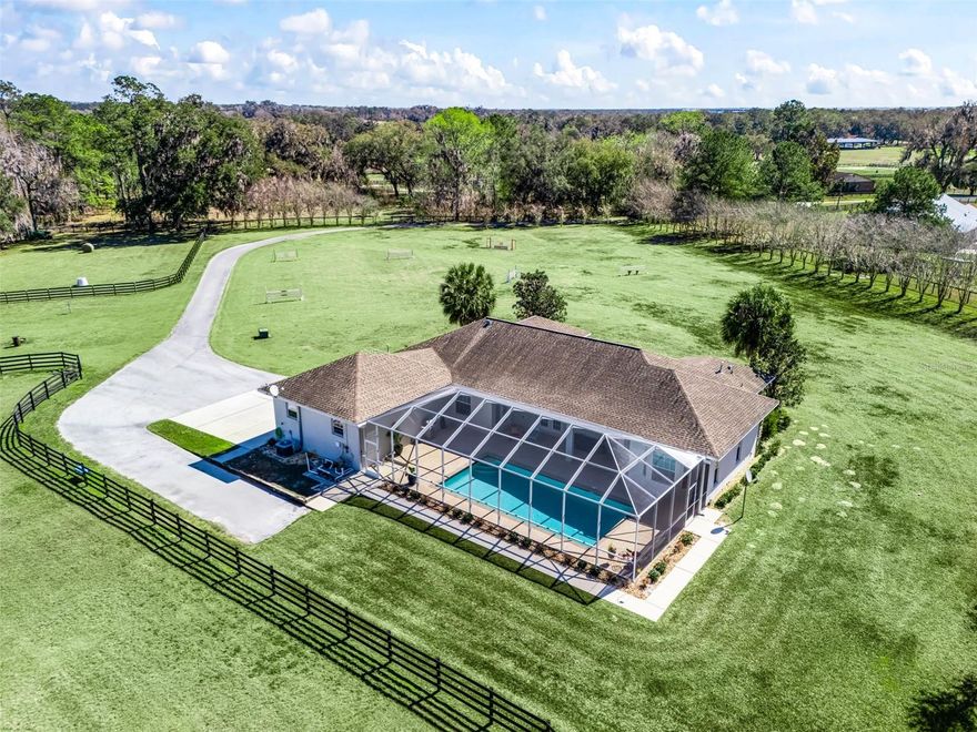 Fantastic 5+ acre horse property well located on a quiet country road just a stones throw away from the World Equestrian Center Ocala! The custom built home is concrete block construction with 4 beds, 4 bathrooms & a large screened-in pool & the property boasts a 2-stall barn, 2 grass paddocks, & grass jumping field. The property is accessed through a gated entrance & asphalt paved driveway which leads past the jumping field to the home & 2-car garage. The house interior has many high-end features such as 10’ ceilings throughout, 8’ tall interior doors, all tile & wood flooring, crown molding, & French doors. The living room boasts a double sided gas fireplace with French doors opening to the covered screen-in pool area. The kitchen has a large quartz island, stainless appliances & gas oven- cooktop. The primary bedroom has wood flooring, is over-sized with direct access to the pool, dual walk-in closets, & ensuite 5-piece bathroom. The 2nd bedroom also has a full en-suite bathroom & walk-in closet. There is also a Generac whole house gas generator with 500 gallon propane tank & well water softener system & the entire property is fenced & ready for you to move in!